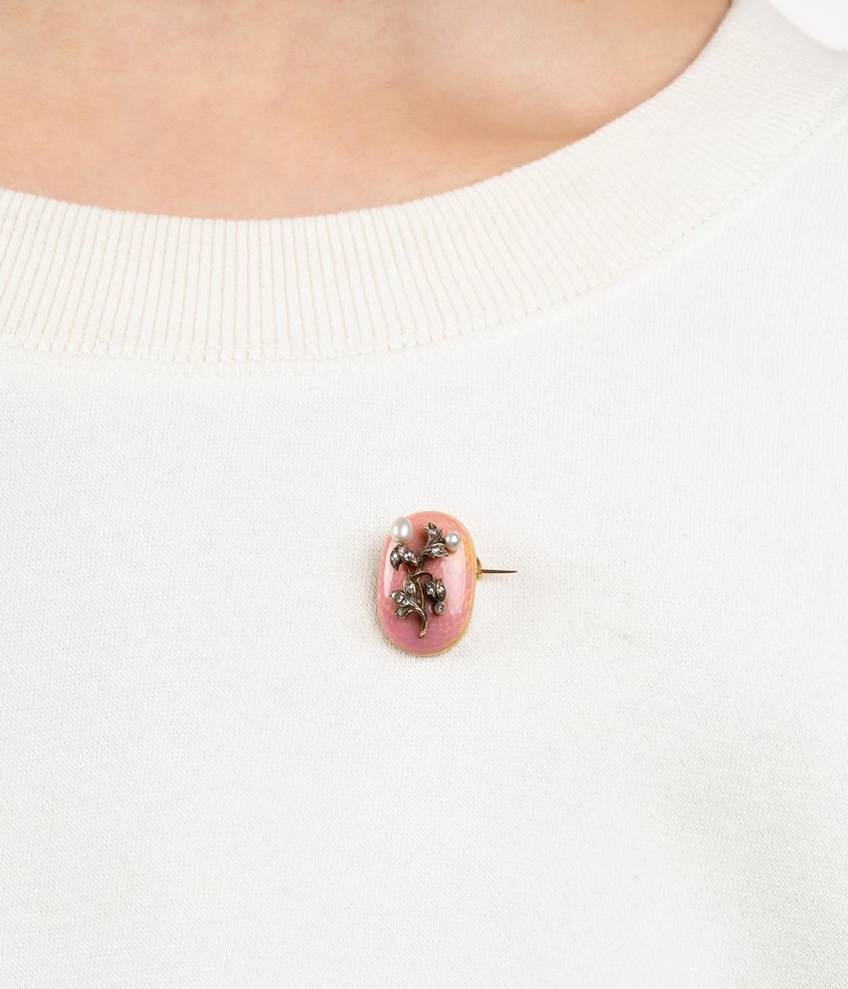 Broche ancienne en or 18 carats (750 millièmes) du début du 20ème siècle. Secondo il gusto di Fabergé, è decorata e decorata con un motivo floreale con diamanti rosa e perle fini.
 
Poids total du bijou : 5,54 g environ.
Hauteur 2,4 cm x Largeur 1,4
