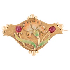 Broche Art nouveau en or à décor d'iris émaillé et de cabochons de rubis