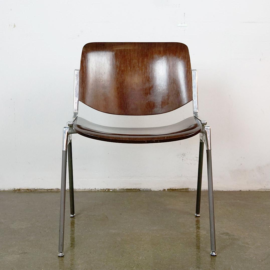 L'iconica sedia impilabile italiana Midcentury Modern DSC 106 è stata disegnata nel 1965 da Giancarlo Piretti per Castelli Italy. Presenta una seduta e uno schienale in legno in ottime condizioni, con alcuni segni di usura dovuti all'età. Anche la