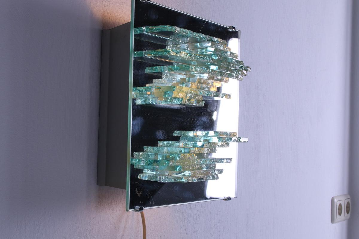 Broken Glass Wall Lamp by Willem Van Oyen for Raak Amsterdam, 1960s

This particularly beautiful wall lamp made of mirror glass and broken glass,
The wall lamp still has its original sticker.

Design by Willem Van Oyen from 1968

model number