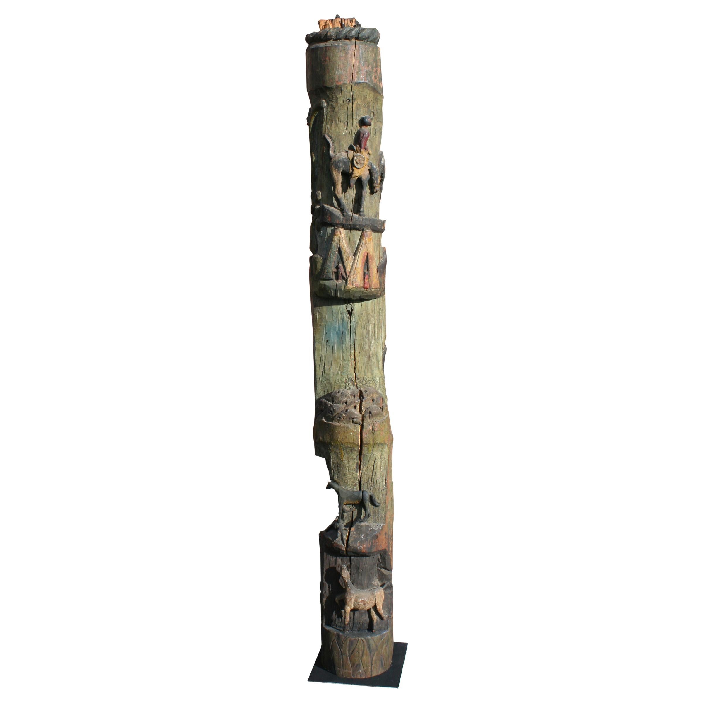 Carved and painted totem with folksy friezes wrapping around pole, depicting imagery of the Wild West; totem painted in colors of red, green, blue, yellow, orange, and black. The totem was passed on to the past owner when Bronco Charlie's favorite