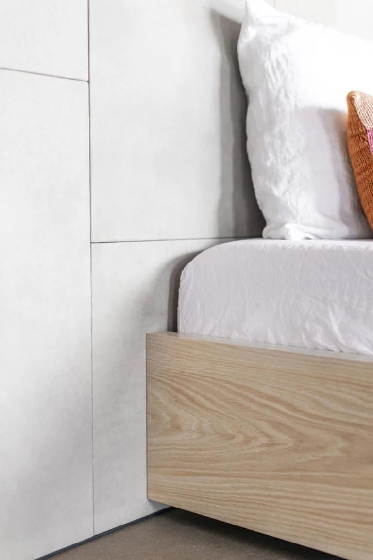 The Bronson Bed features an oversized headboard made up of asymmetric leather paneling, adding subtle detail to the surface of the piece. This feature, combined with low profile footboard and side rails create a minimalist design despite the scale