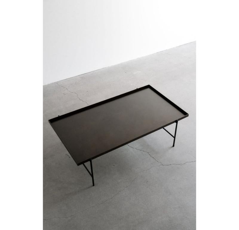 La table cocktail Bronson est une pièce maîtresse élégante et moderne pour tout espace de vie. Le mince cadre noir mat de la table donne une touche contemporaine au design, tandis que le plateau en acier noirci ajoute une sophistication