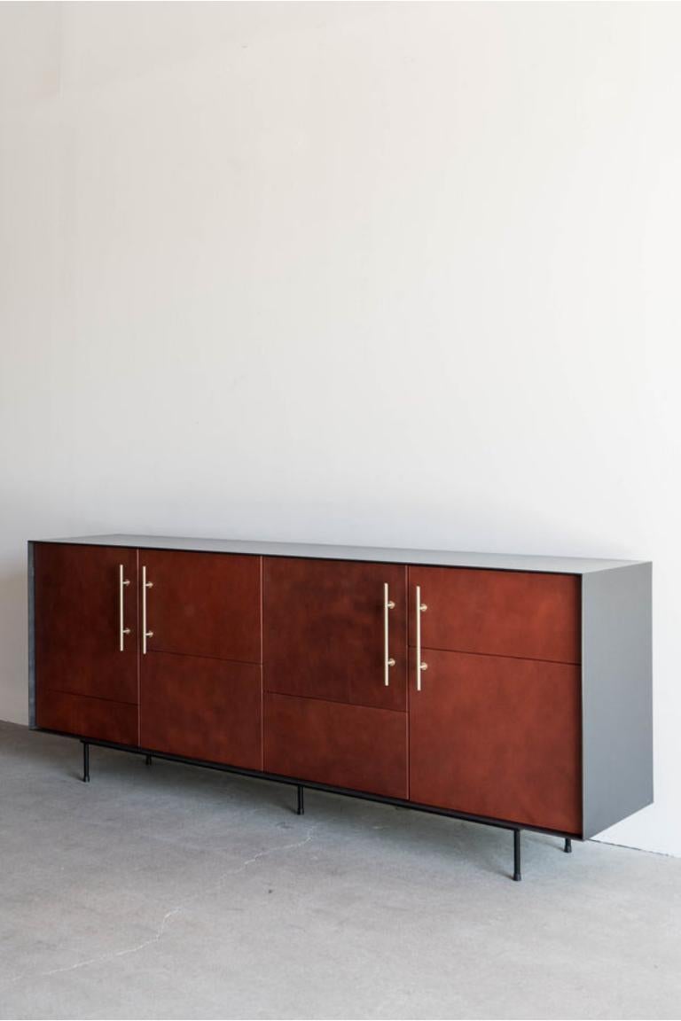 La credenza Bronson è realizzata a mano a Los Angeles, in California. Il design unico del pezzo trae la sua estetica originale dalla combinazione del classico involucro in metallo e delle raffinate ante in pelle. L'involucro in acciaio industriale,