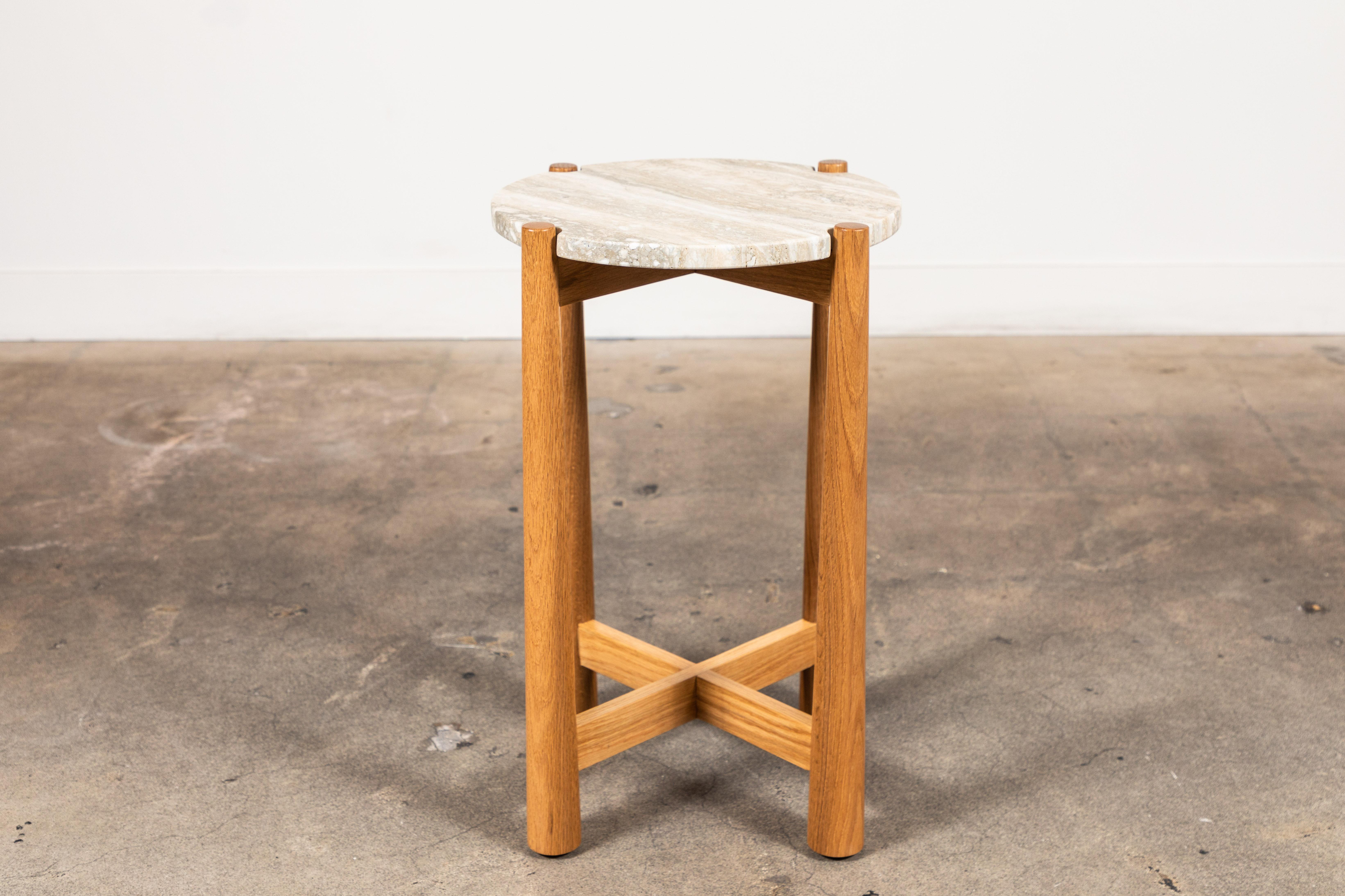 La table à boissons Bronson est dotée d'un plateau rond en pierre avec des coins dentelés qui reposent sur une base détaillée en noyer ou en chêne. 

La Collection Lawson-Fenning est conçue et fabriquée à la main à Los Angeles, en Californie.