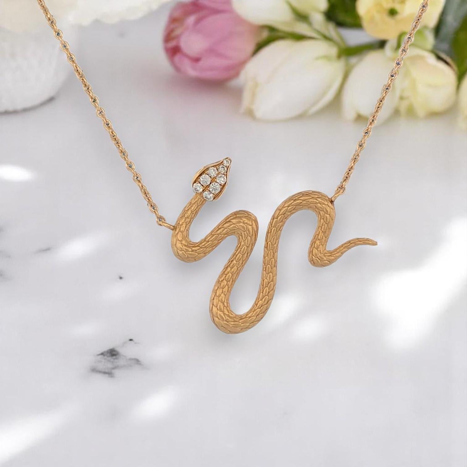 The Bronte serpent necklace coils with quiet power in 18k yellow gold, its etched scales glittering with 0.07 carats of natural diamonds. This symbolic piece features an adjustable 16-18