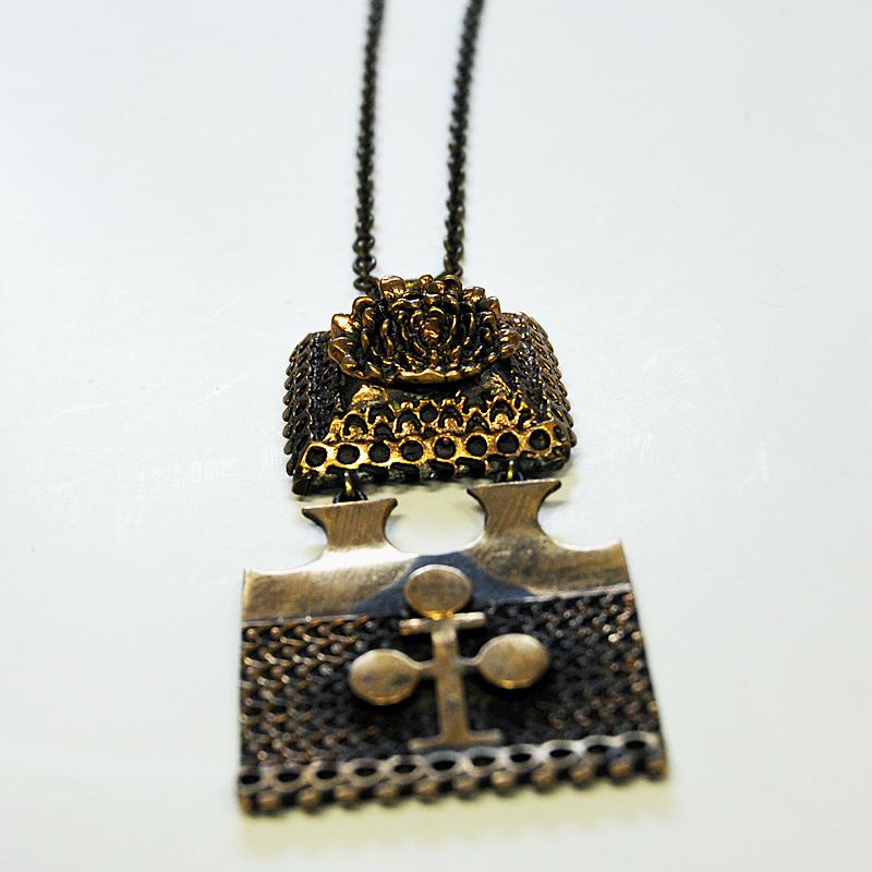 Bellissima collana vintage in bronzo composta da due pezzi collegati tra loro come un unico ciondolo. Catena originale in bronzo del designer Pentti Sarpaneeva per Torun Hopea, Finlandia, anni Settanta. Patina naturale con bei rilievi e decorazioni.