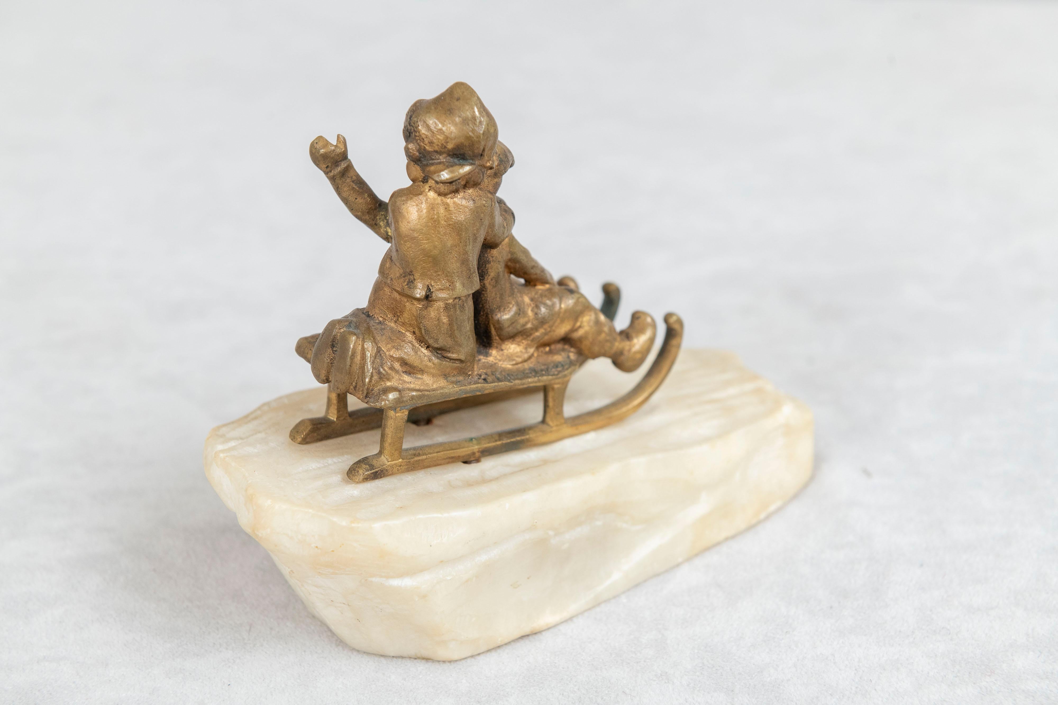 Belle Époque Bronze, 2 Young Children Riding on Sled on Carved White Marble Base ca. 1895 For Sale