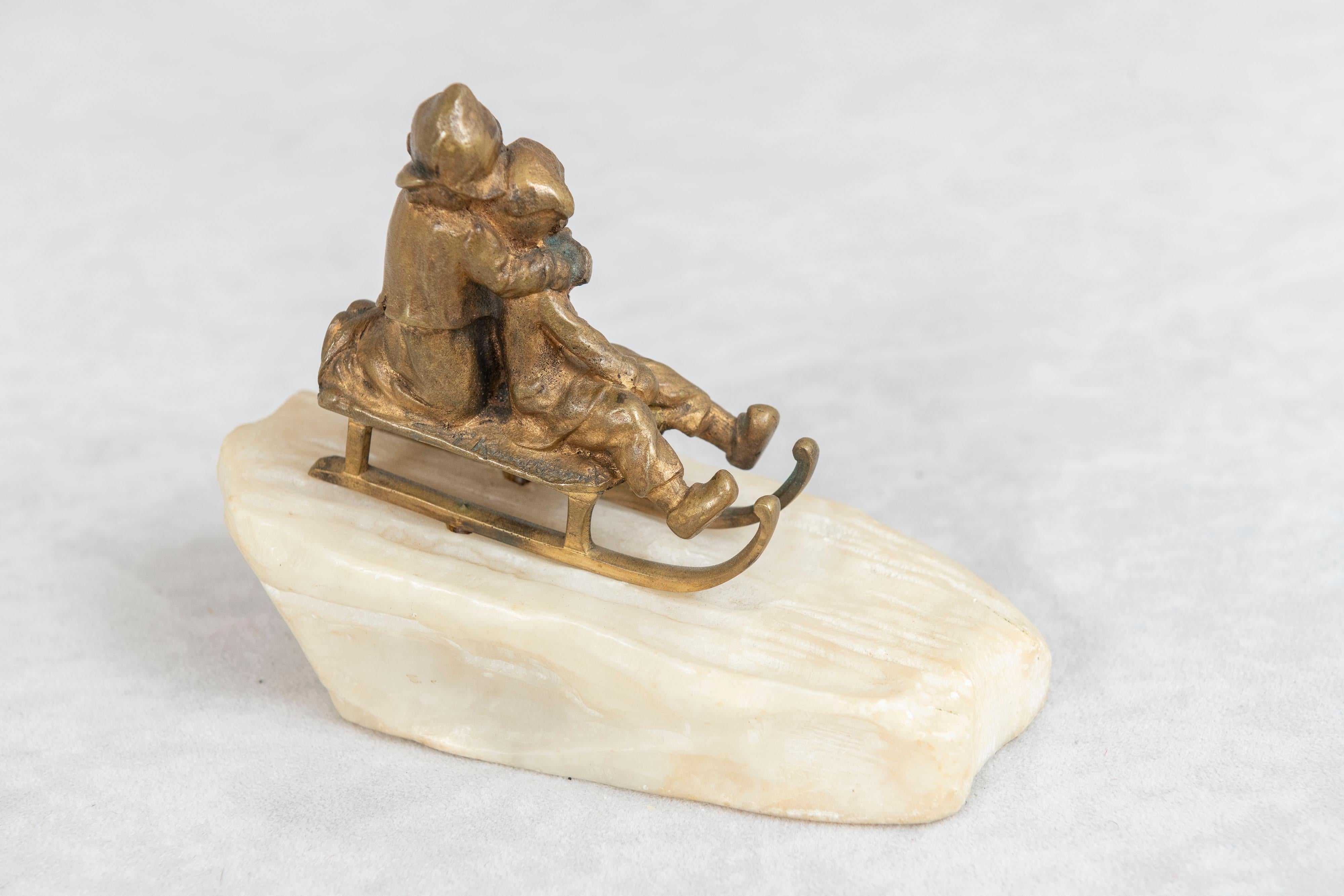 German Bronze, 2 Young Children Riding on Sled on Carved White Marble Base ca. 1895 For Sale