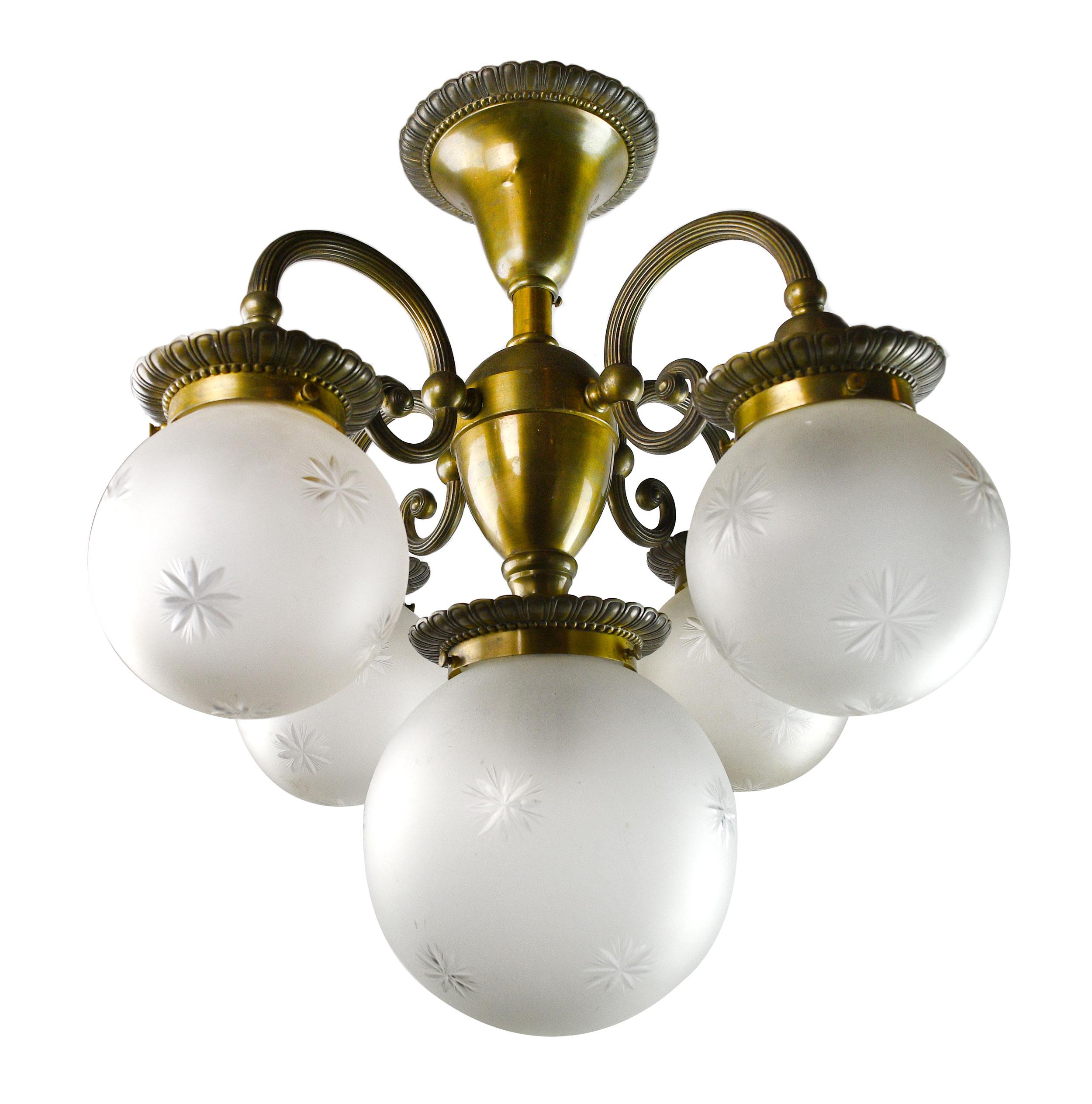 This finely crafted 5-light chandelier is made of cast bronze and features a large center globe surrounded 4 slightly smaller globes, each is hand cut.
There are two globe designs available, a floral design and a starburst design. 

Chose you glass