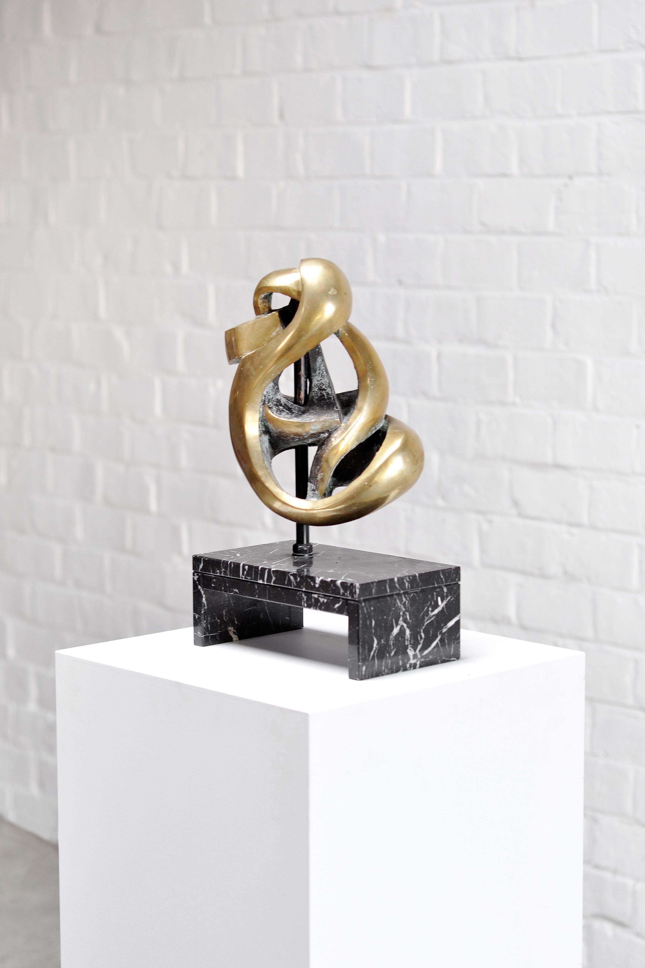 A beautiful abstract bronze sculpture on a black marble base in the style of Belgian artist Jean-Pierre Ghysels. Unsigned. This piece has an amazing and different presence from every angle. Conveys the spirit of modernism from the early 70's. Cast