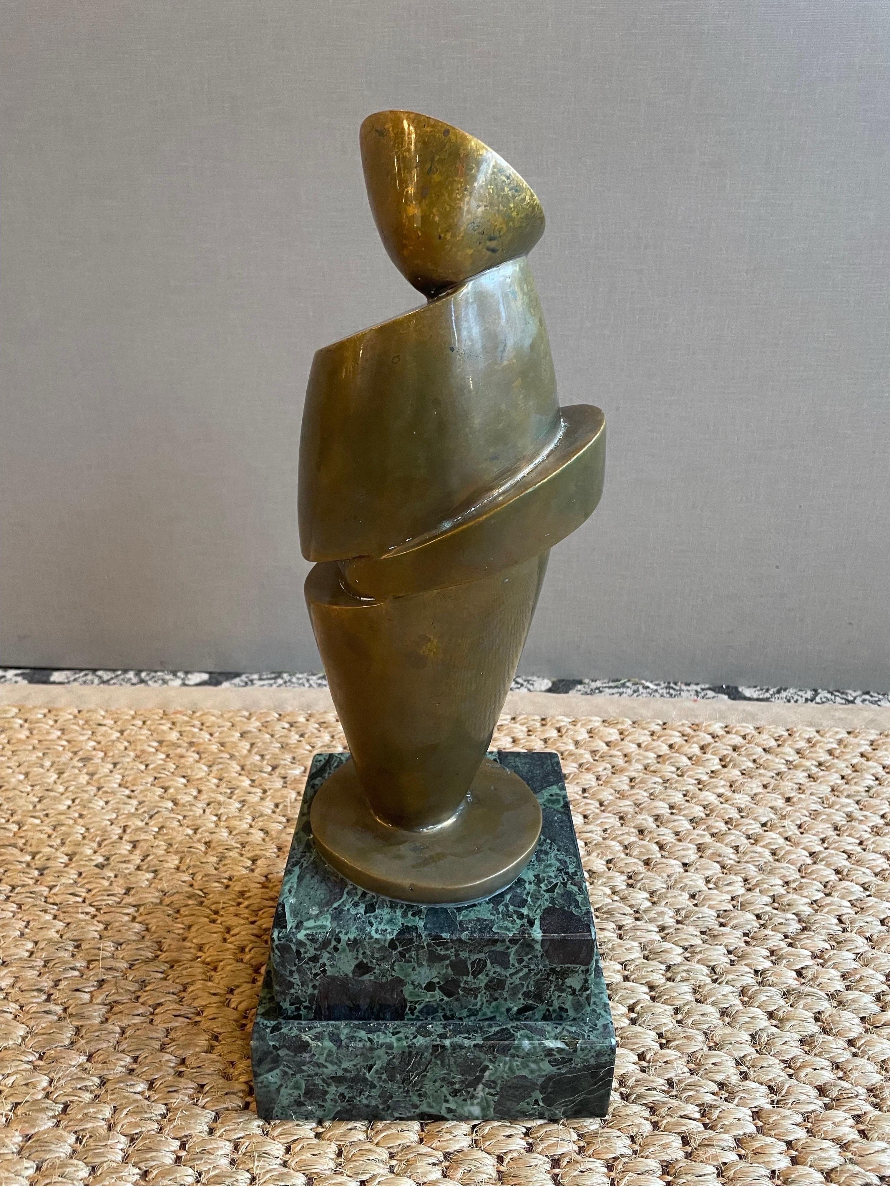 This is a heavy bronze abstract sculpture by Peter Calaboyias . He titled it psyche no.2 and did it in 1983. It is mounted on a green marble tiered base 