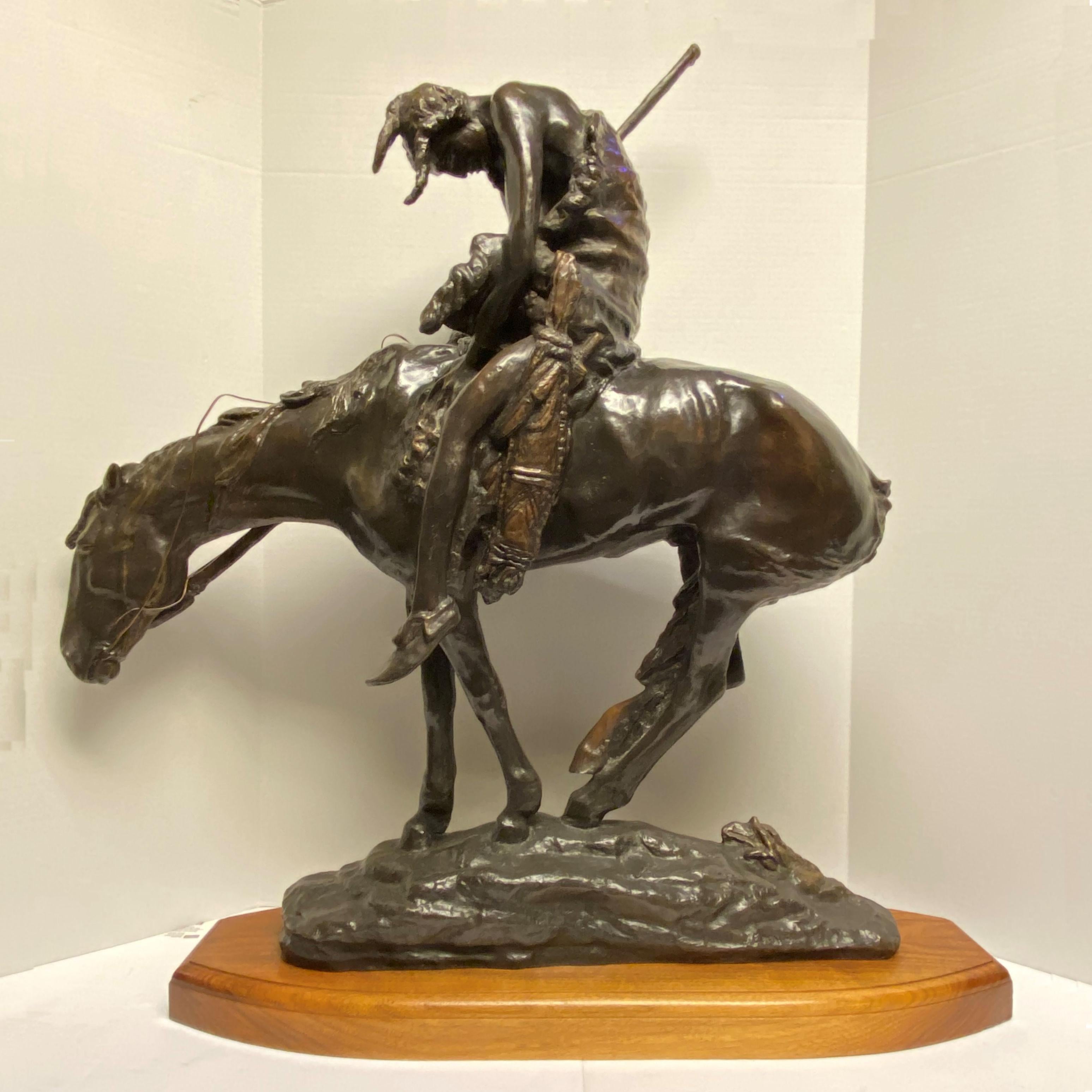 Bronze After James Earl Fraser (1876-1953) Entitled End of the Trail, mounted on craved, stained wooden base.