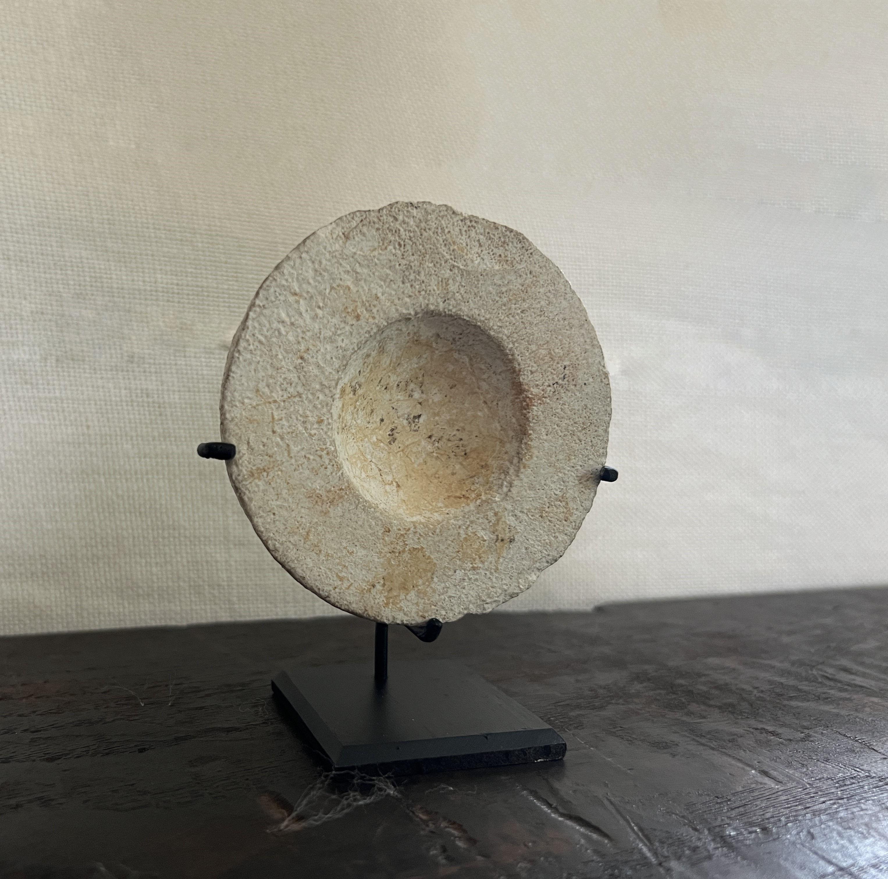 Ancient Near East, Holyland, Late Bronze Age, Deir Samit, Judea, ca. 1500 to 1250 BCE. A lovely limestone cosmetic dish presenting a hemispherical body with a flattened top and a depression at the center. Incised grooves wrap horizontally around the