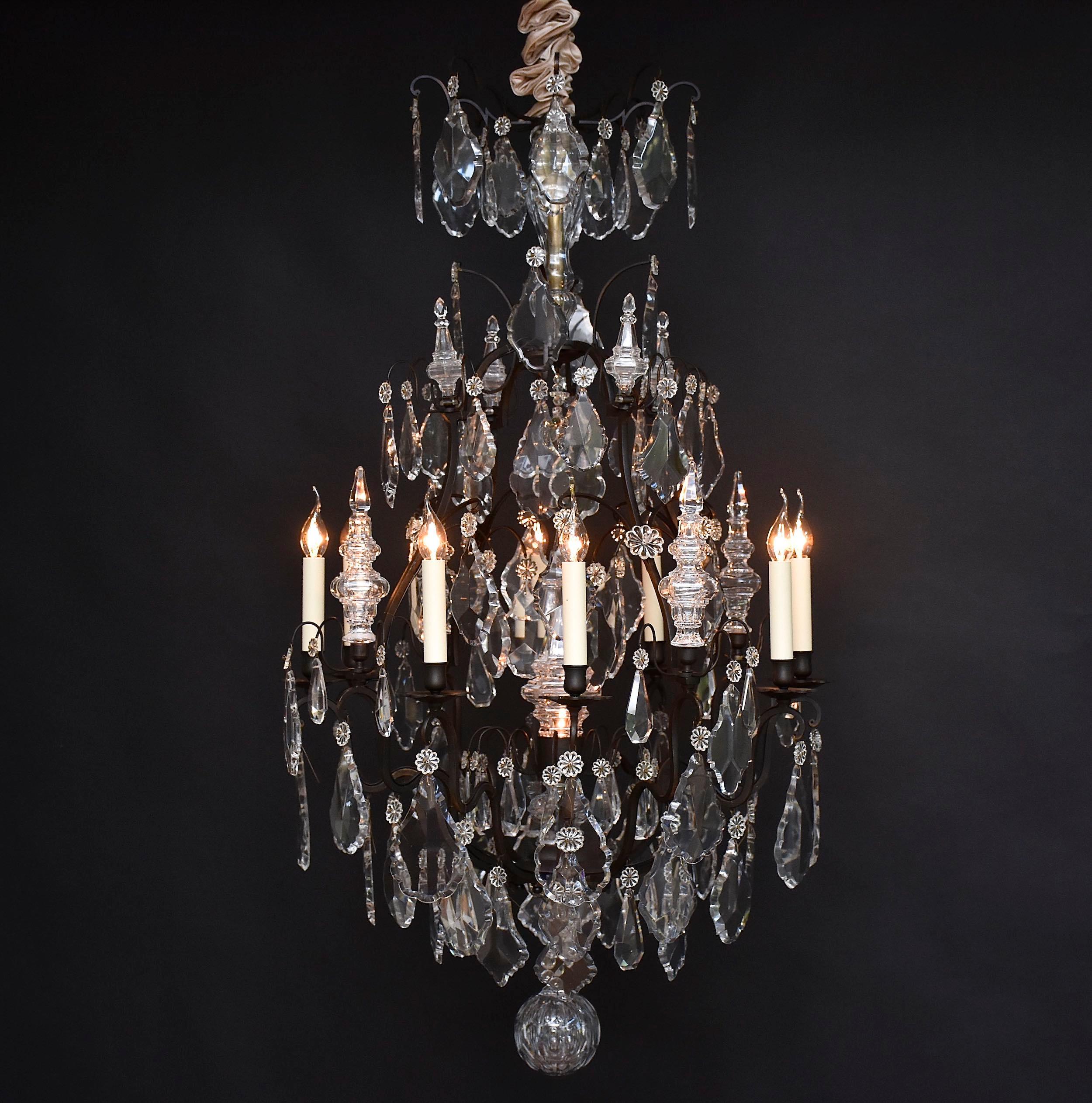 Un magnifique lustre français avec 8 lumières autour du lustre. Patine foncée d'origine.
Forme 'cage' ; avec 12 bras en forme de bougie et 4 bras principaux en forme de 'cage'.
Les bras 
