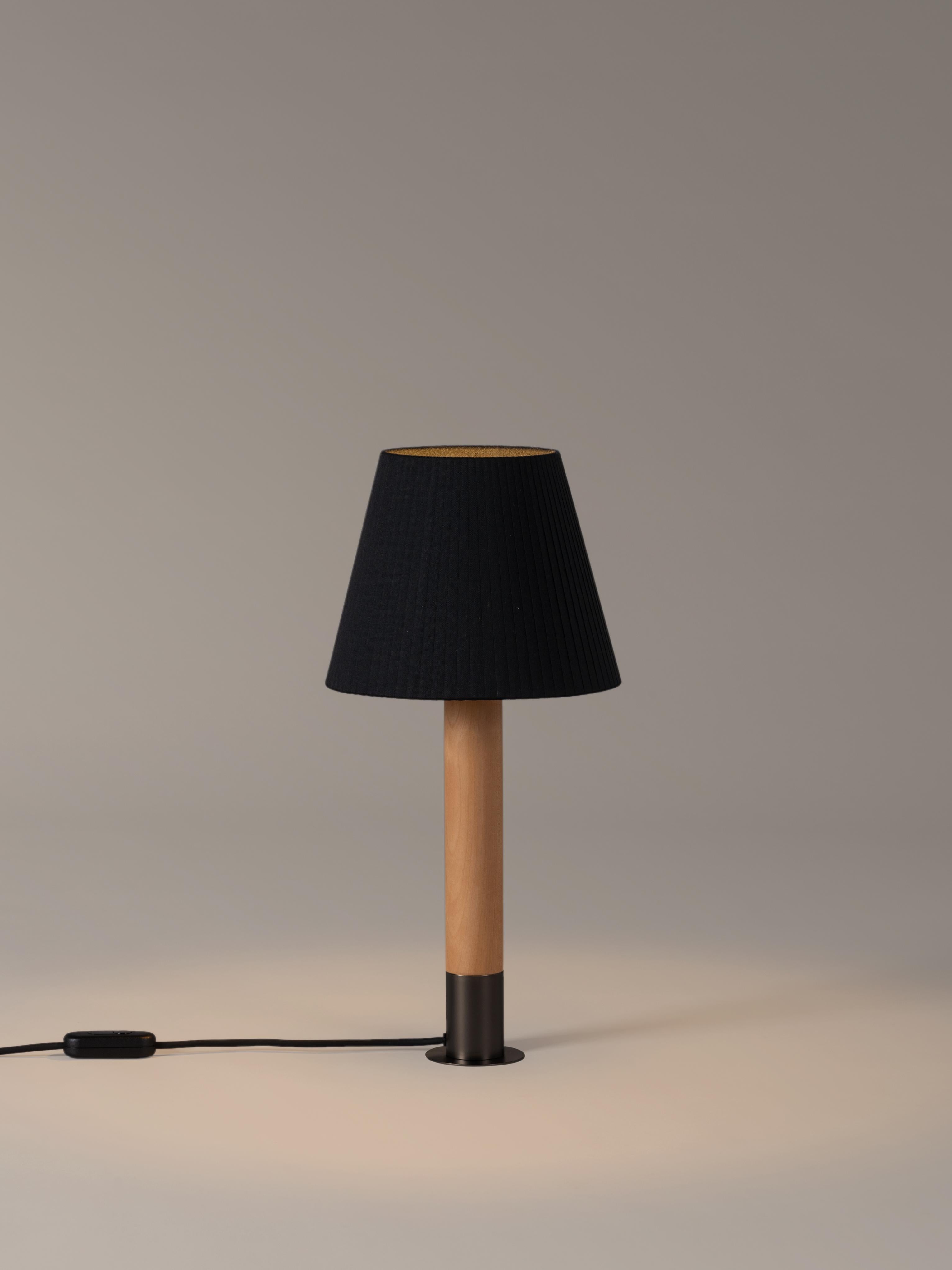 Bronze and black Básica M1 table lamp by Santiago Roqueta, Santa & Cole
Dimensions: D 25 x H 52 cm
Materials: bronze, birch wood, ribbon.
Available in other shade colors and with or without the stabilizing disc.
Available in nickel or