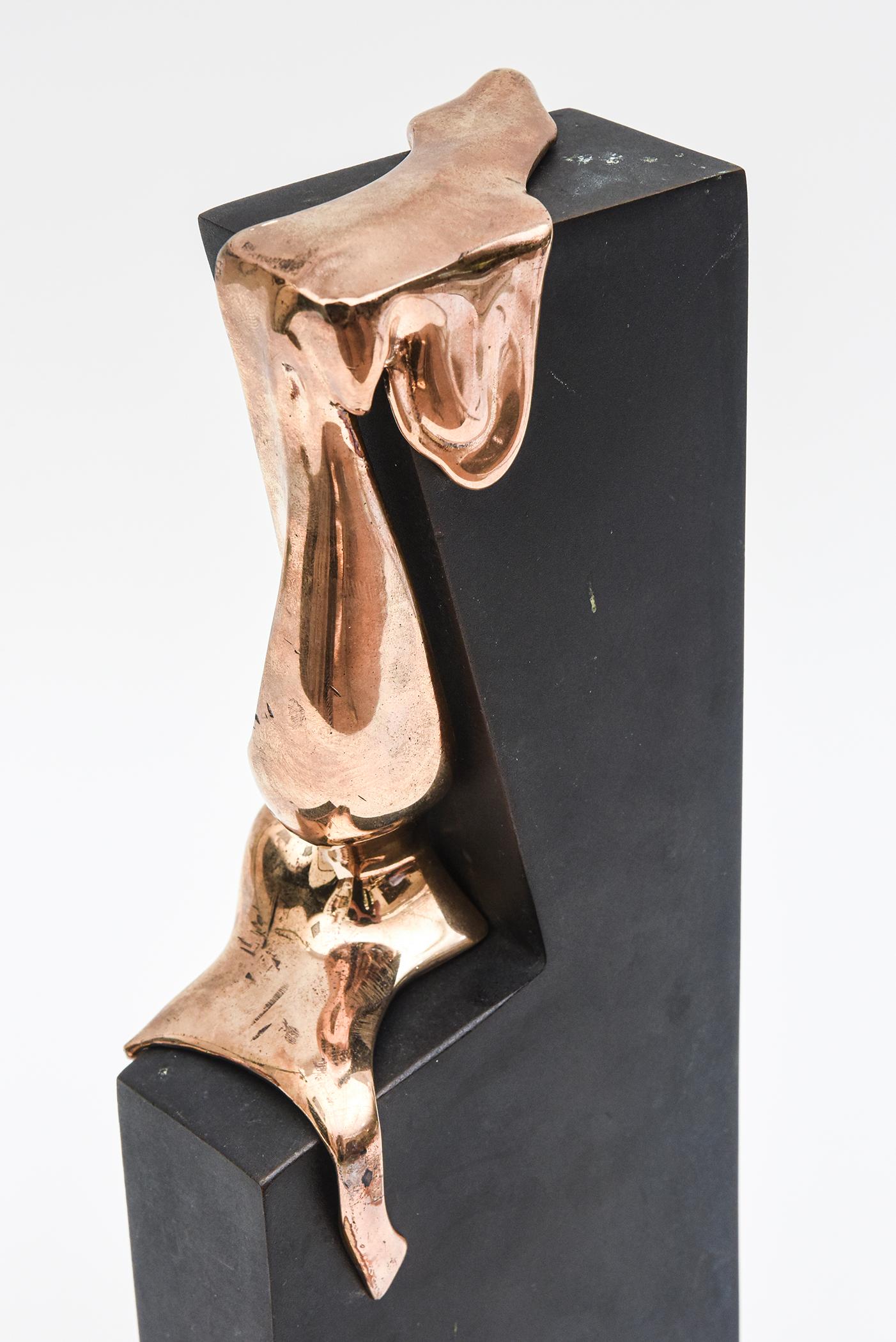 Cette sensuelle et fabuleuse sculpture vintage signée en édition limitée en 2 parties est en bronze fondu cascadant dans une forme de corps perché au sommet de la base en métal noir. Le bronze ressemble à de l'or rose. Le bronze se détache pour être