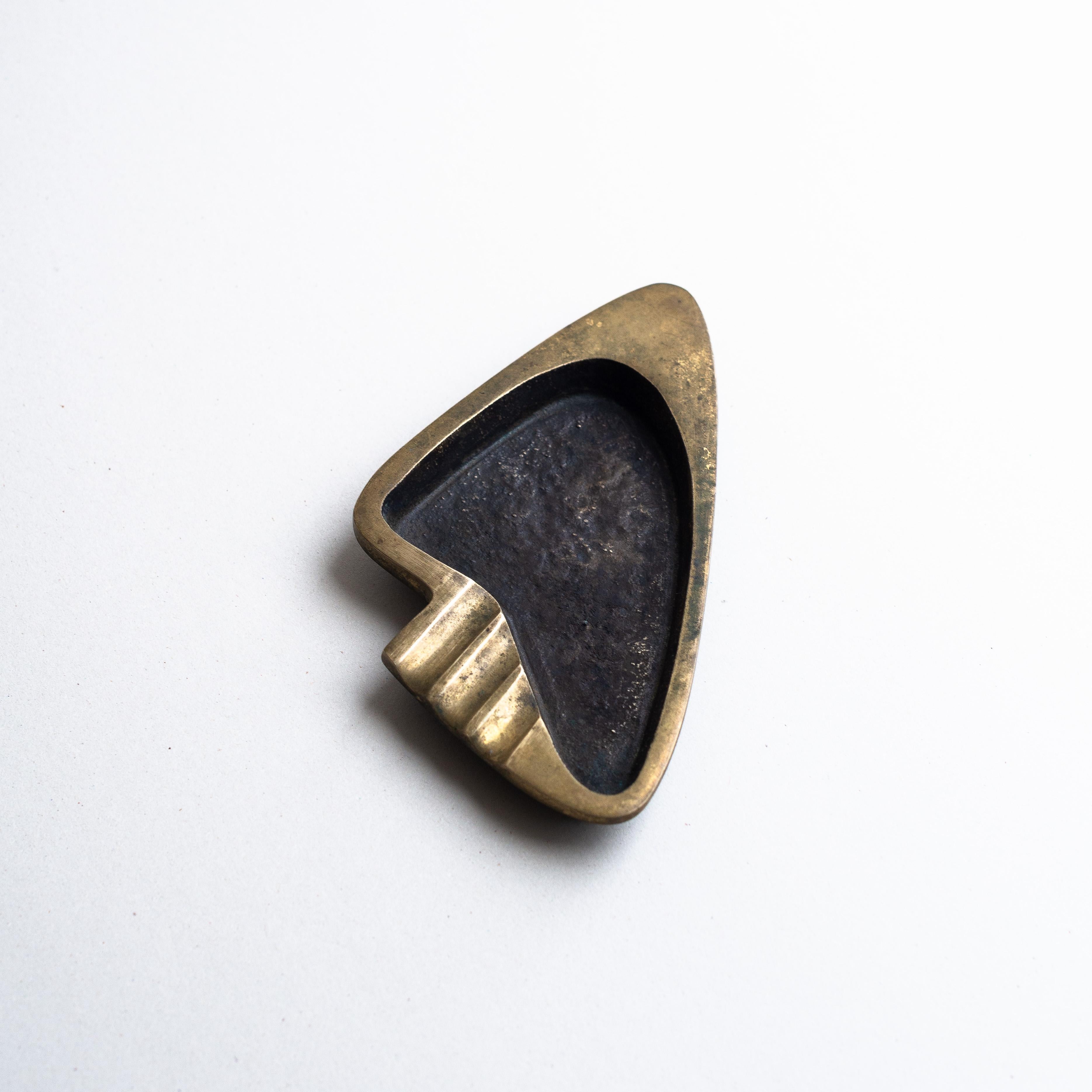 Aschenbecher aus Bronze und Messing, Franz & Karl Hagenauer, Österreich 1950

Skulpturaler Aschenbecher im eleganten und stromlinienförmigen Stil der Moderne. 

Das aus Bronze und Messing gefertigte Stück verbindet Schlichtheit mit einem Hauch von