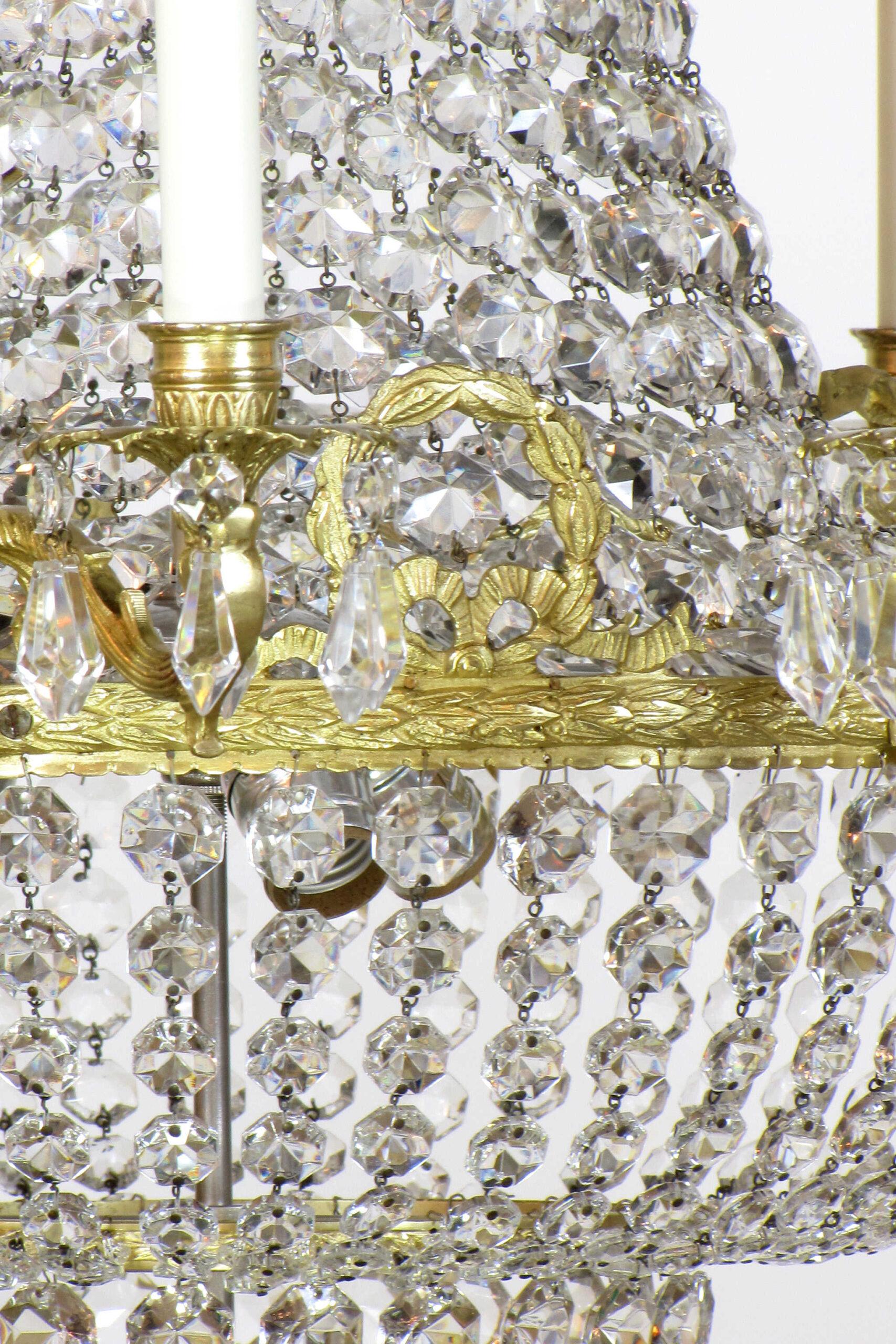 Brass and crystal chandelier. Twelve lights around ring, and three in the center of the basket. C. 1920.

Dimensions: 
Height: 32