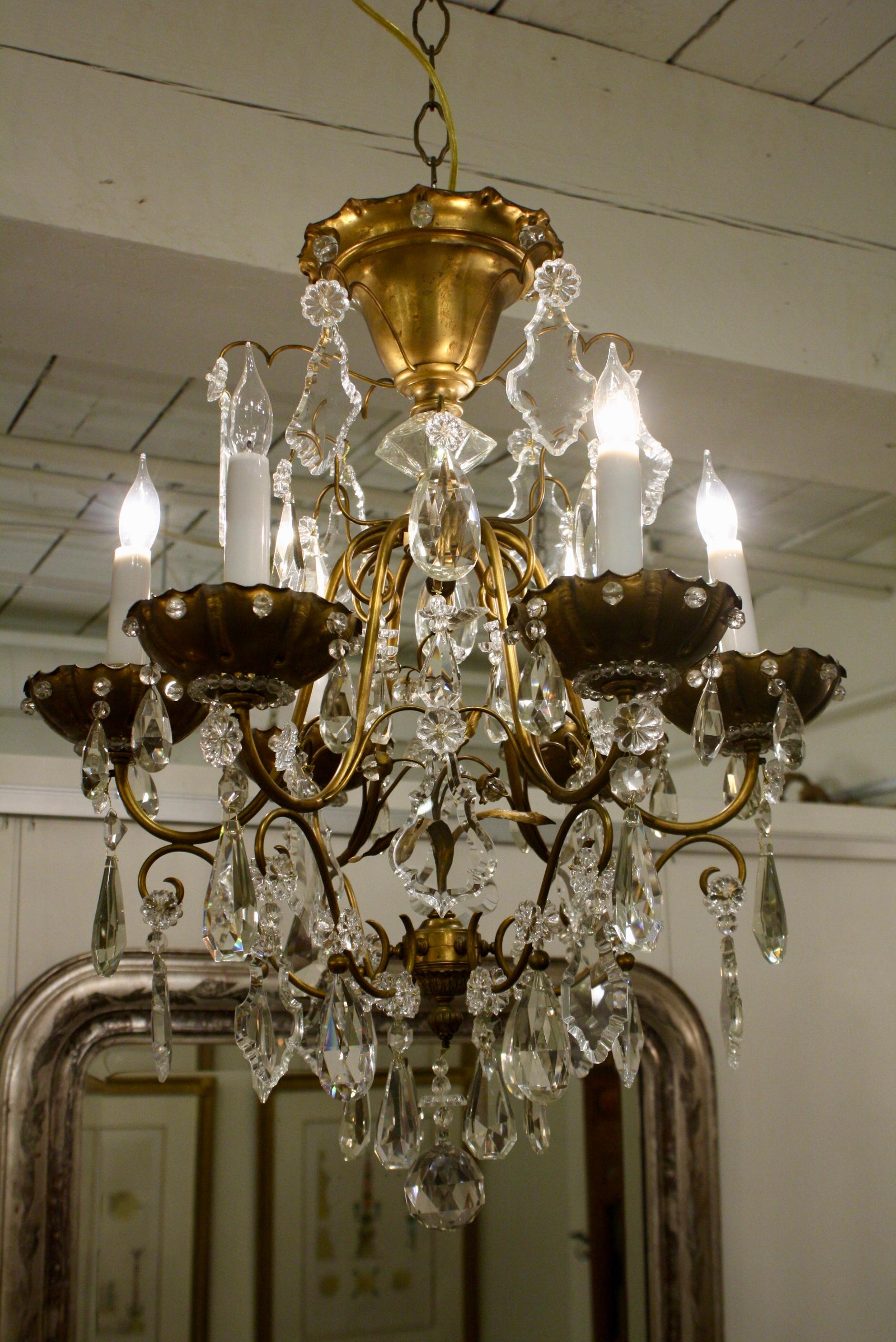 French bronze and crystal cage-form chandelier with six lights attributed to Maison Jansen. This chandelier is ornamented with a variety of different cut crystal pendalogues and pierced bobesches with crystal beads. The interior features a decorate