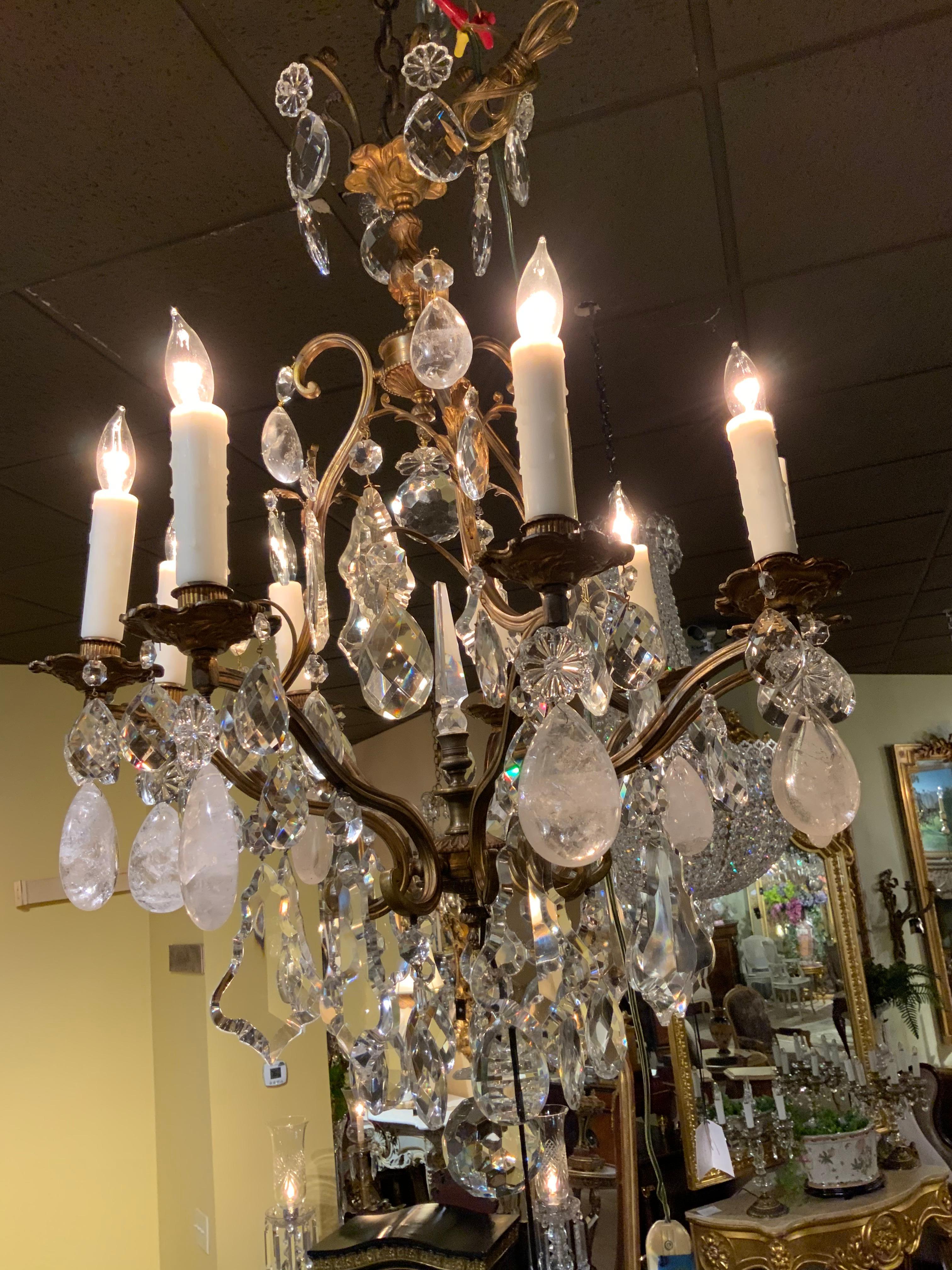 Antique fixture with scrolling arms and nine lights. It is enhanced with a central spire. The gilding is a soft antique patina.
Clear beautiful crystal and large rock crystal make this a special piece.