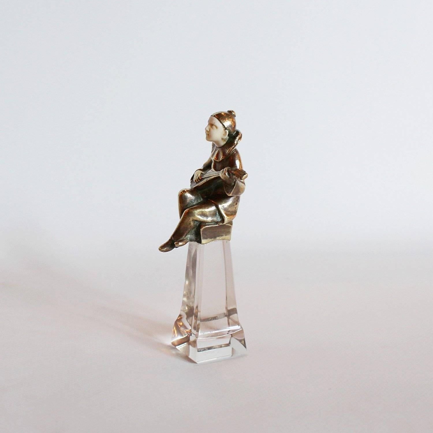 A bronze, crystal and ivory wax seal stamp. Stamp is not engraved. Set over with a small seated figure of a Pierrot holding a lyre.
 
