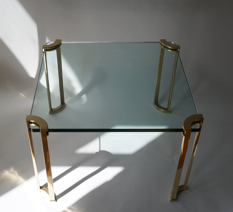 Stunning bronze and glass side or cocktail table from the early 1970s.This example handsomely wraps around the glass top with solid bronze legs with architectural detailing.

