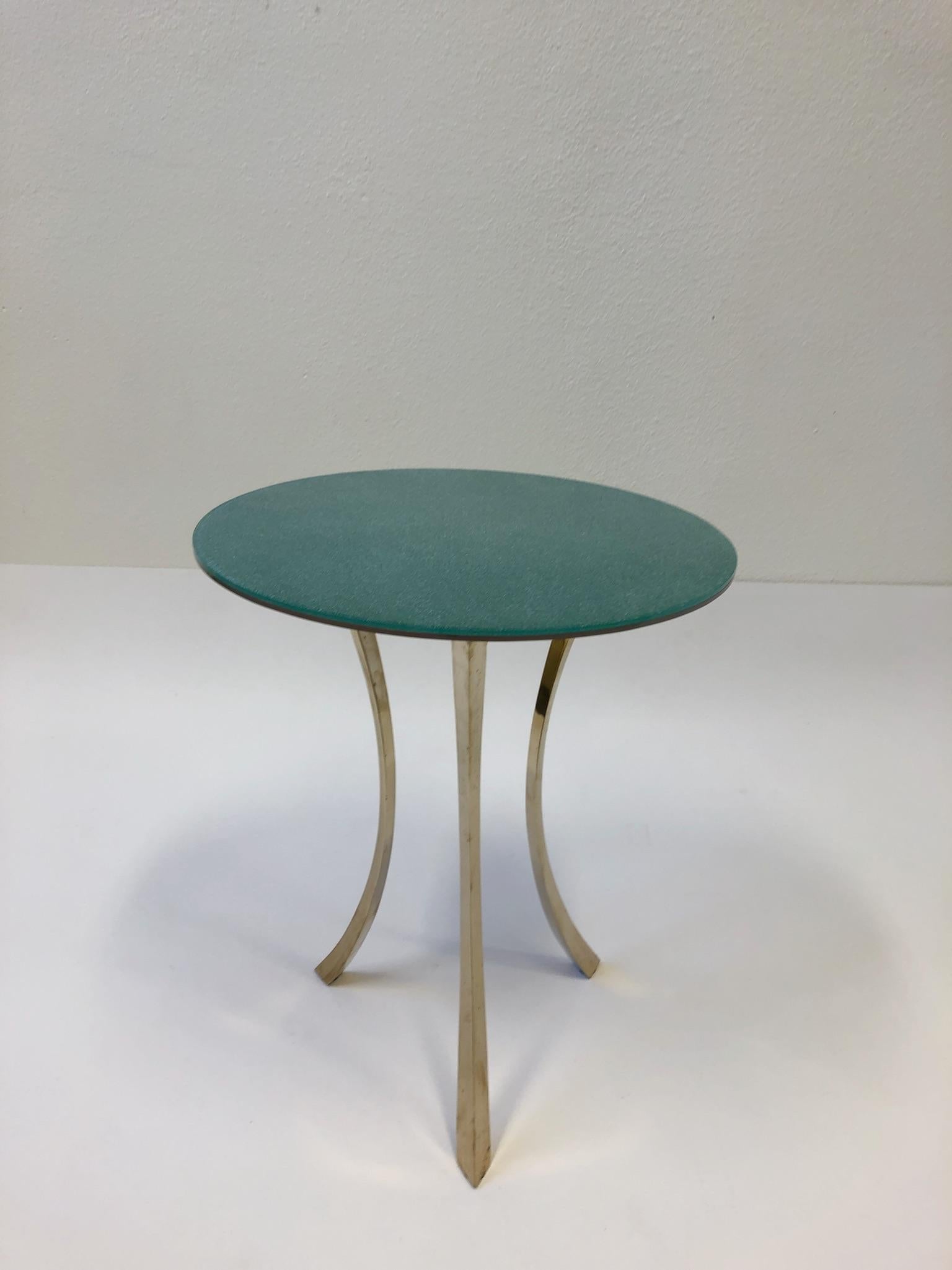 A beautiful solid polish bronze and glass occasional table with a reversi glass top. One side is emerald green with white speckles and the other os pink with white speckles. 

Measures: 18” diameter 21.5” high.