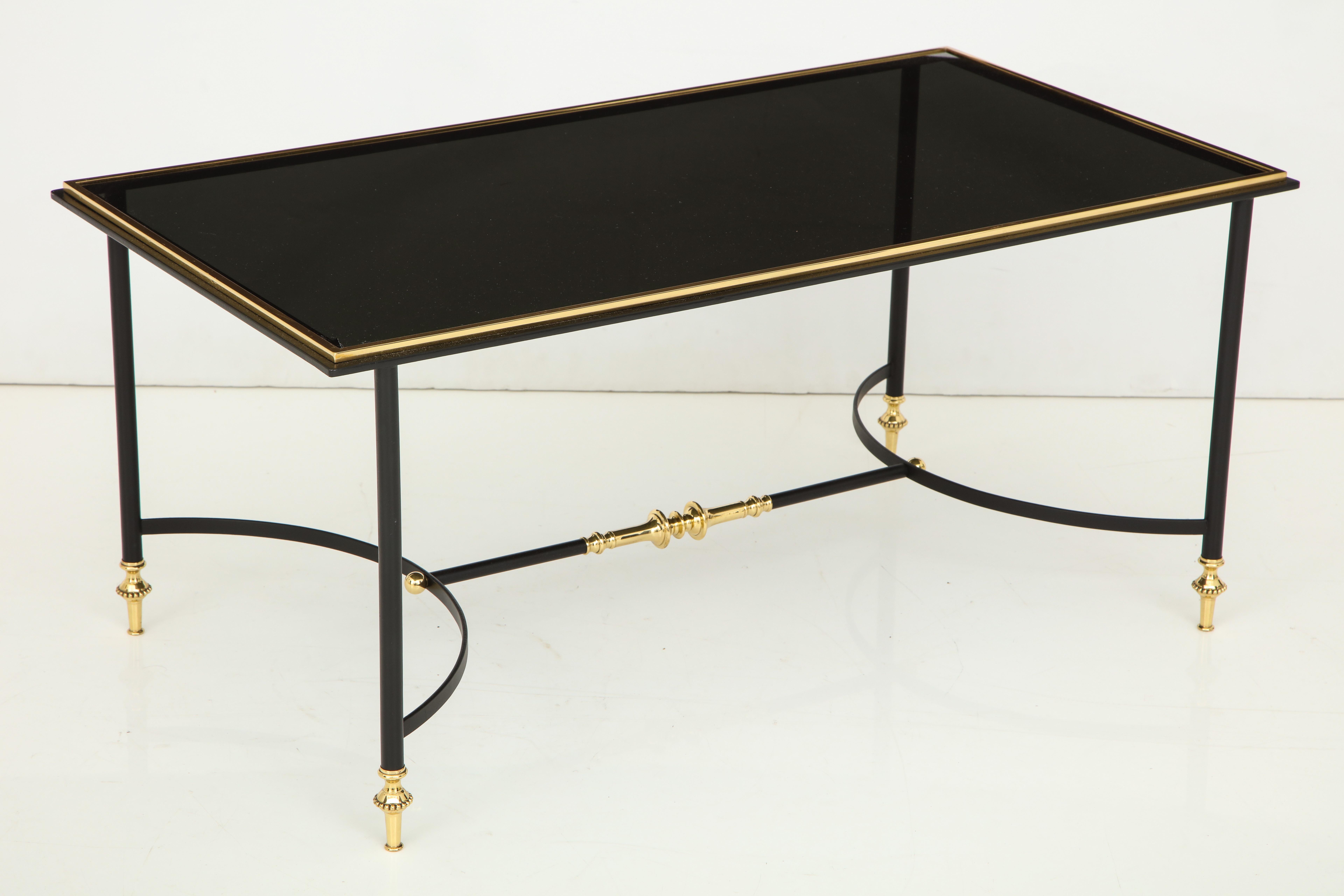 Bronze and iron coffee table with black glass top and shaped stretcher.