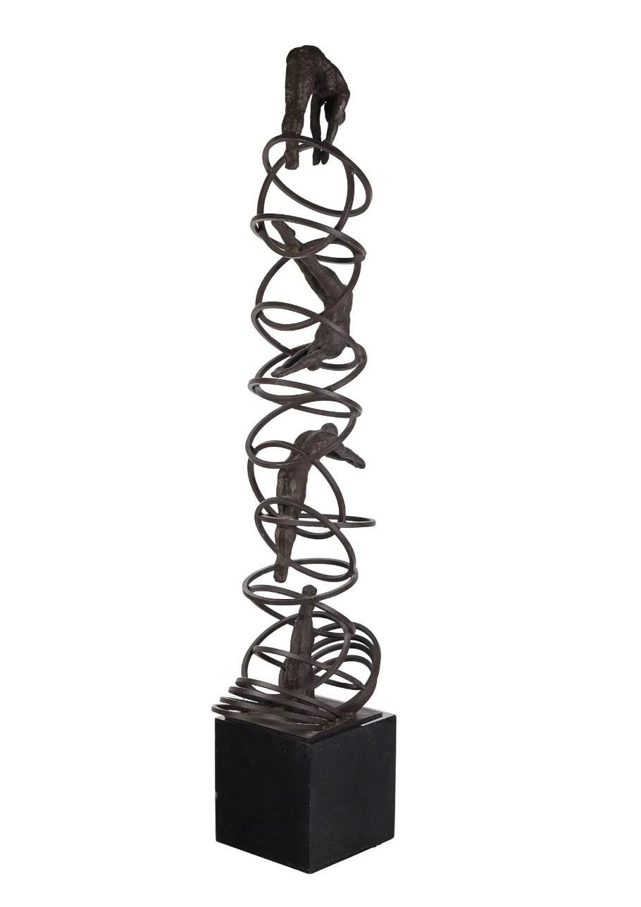 Bronze and iron sculpture featuring abstract human figures in climbing poses integrated within a network of interwoven metal rings. The vertically structured composition combines textured bronze forms with spiraling iron circular elements, evoking