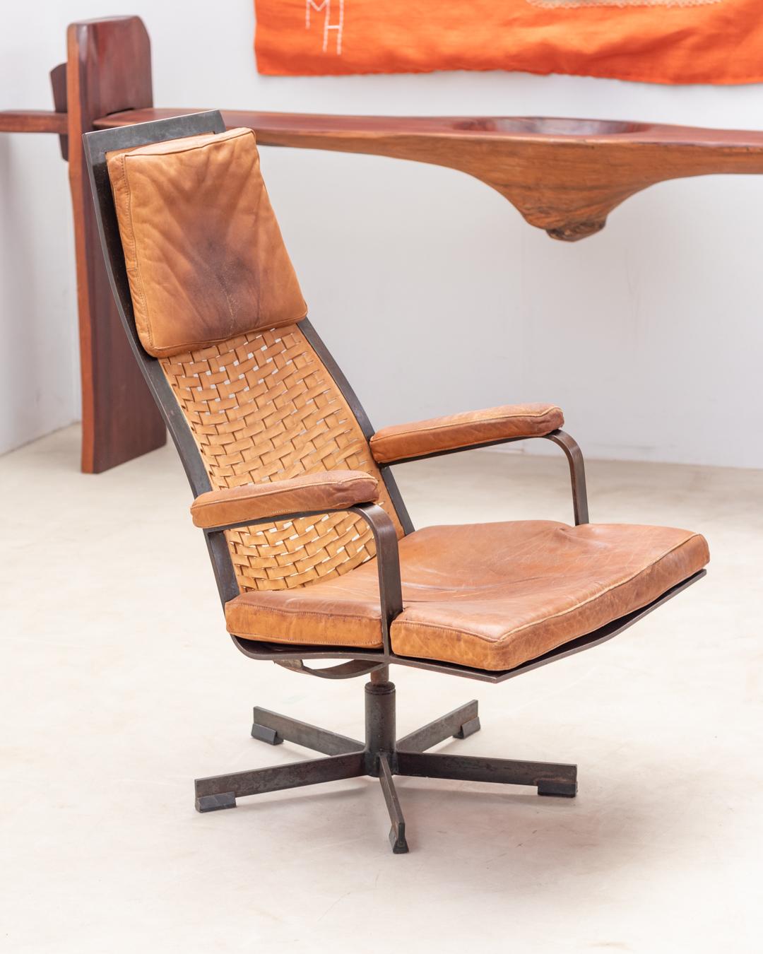 This leather swivel armchair from 1970s’ is a timeless design. 
The frame is crafted from bronze The patina, developed through years of oxidation, lends the bronze frame a distinctive aged charm.  
For the backrest, a light-brown woven leather is