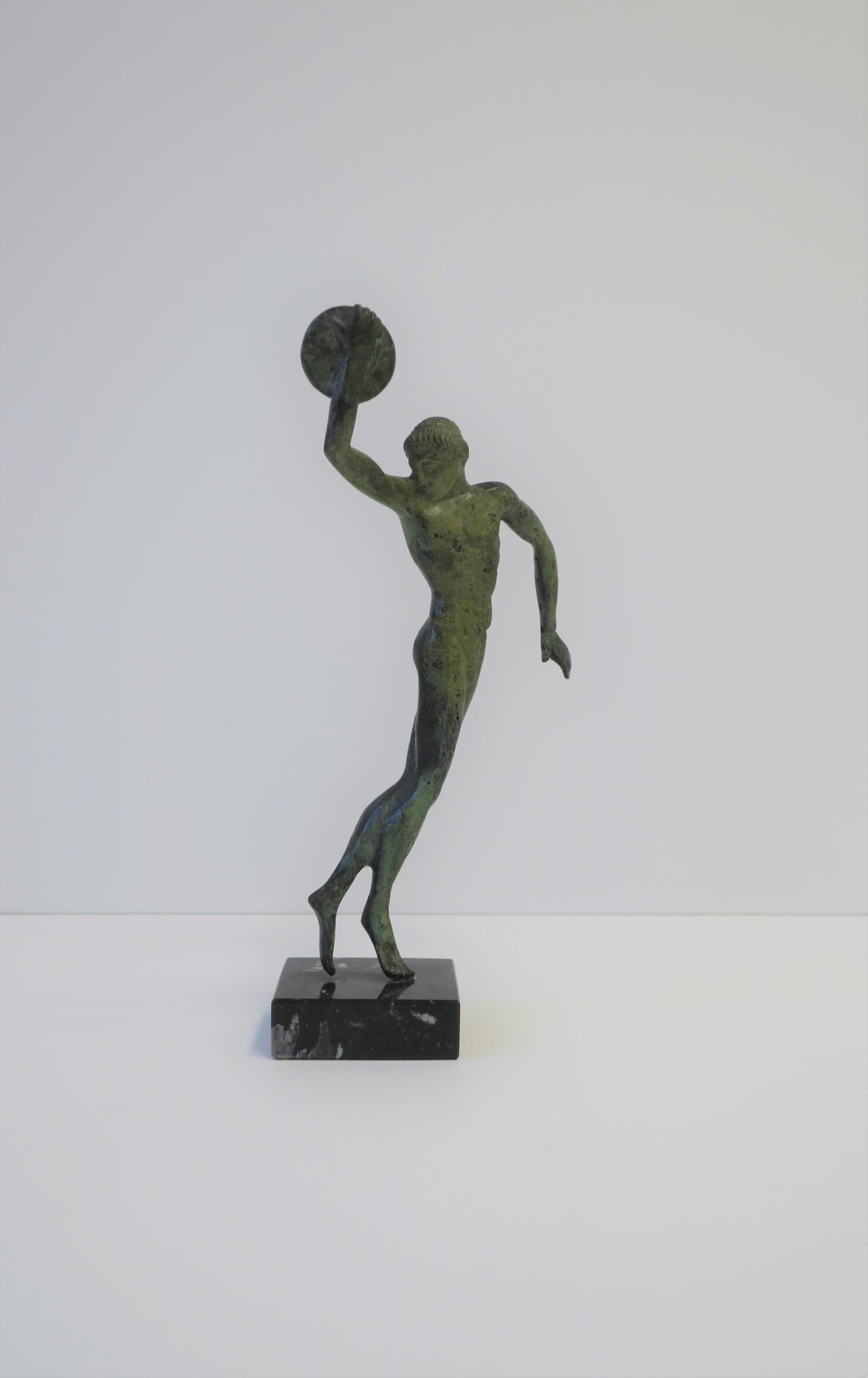 A bronze Classical Greek sculpture piece of male figure 'Discobolus'. Bronze sculpture has a verdigris patina and a black marble base. Piece measures: 8.5