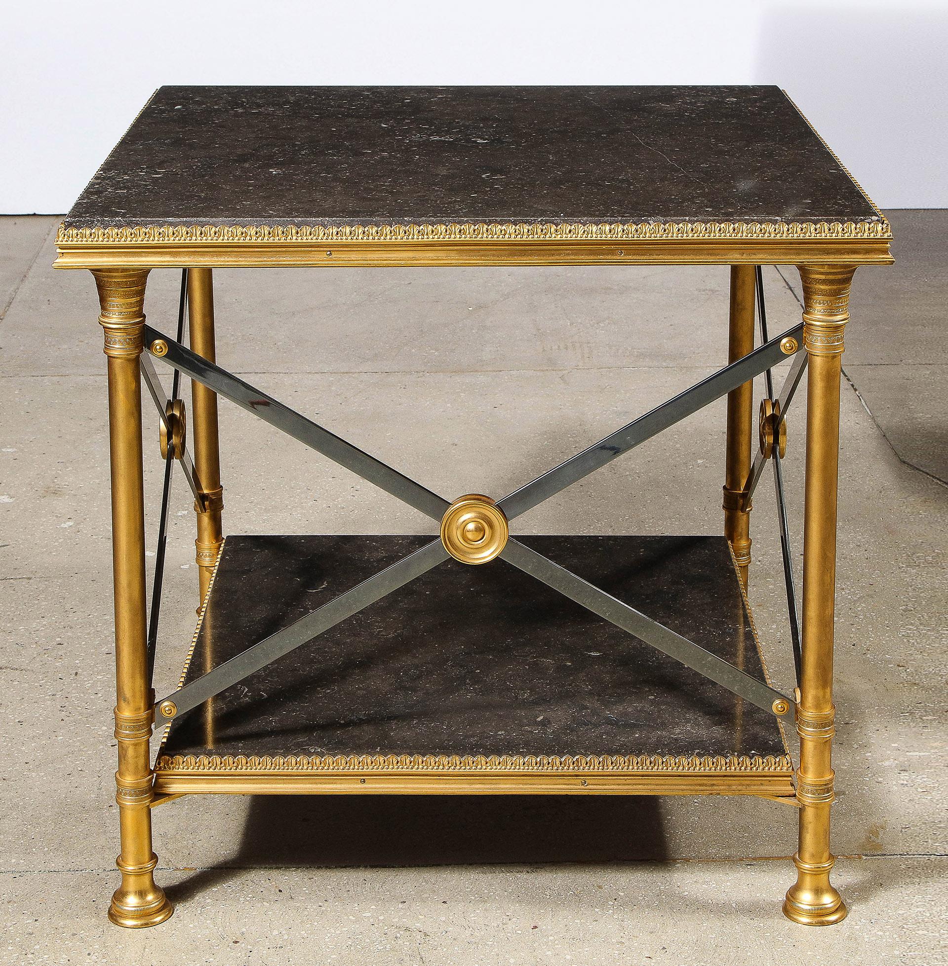 The two tier marble and bronze table with an intricately detailed cast bronze frame, 3 sides with steel and bronze cross slats. 
Having original Maison Jansen label.