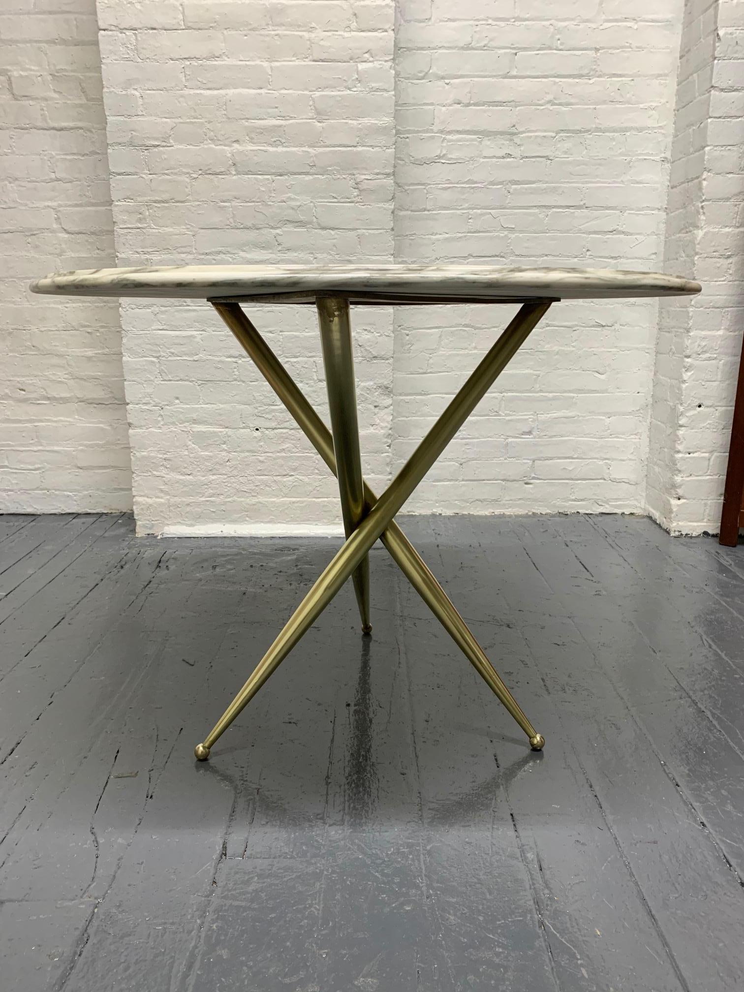 Bronze and marble-top side table in the style of Gio Ponti. Has bronze tri-pod legs with ball feet.