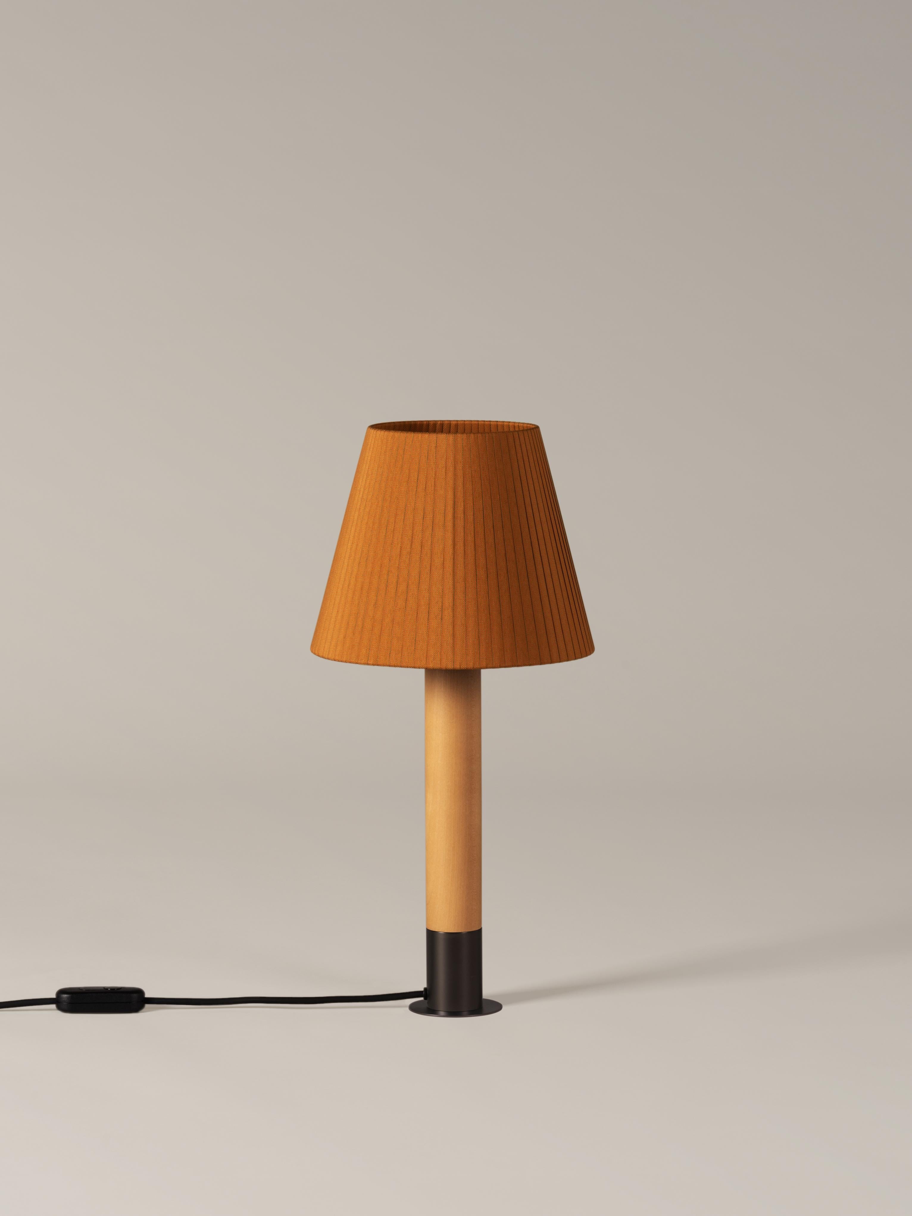 Bronze and Mustard Básica M1 table lamp by Santiago Roqueta, Santa & Cole
Dimensions: D 25 x H 52 cm
Materials: Bronze, birch wood, ribbon.
Available in other shade colors and with or without the stabilizing disc.
Available in nickel or bronze.

The