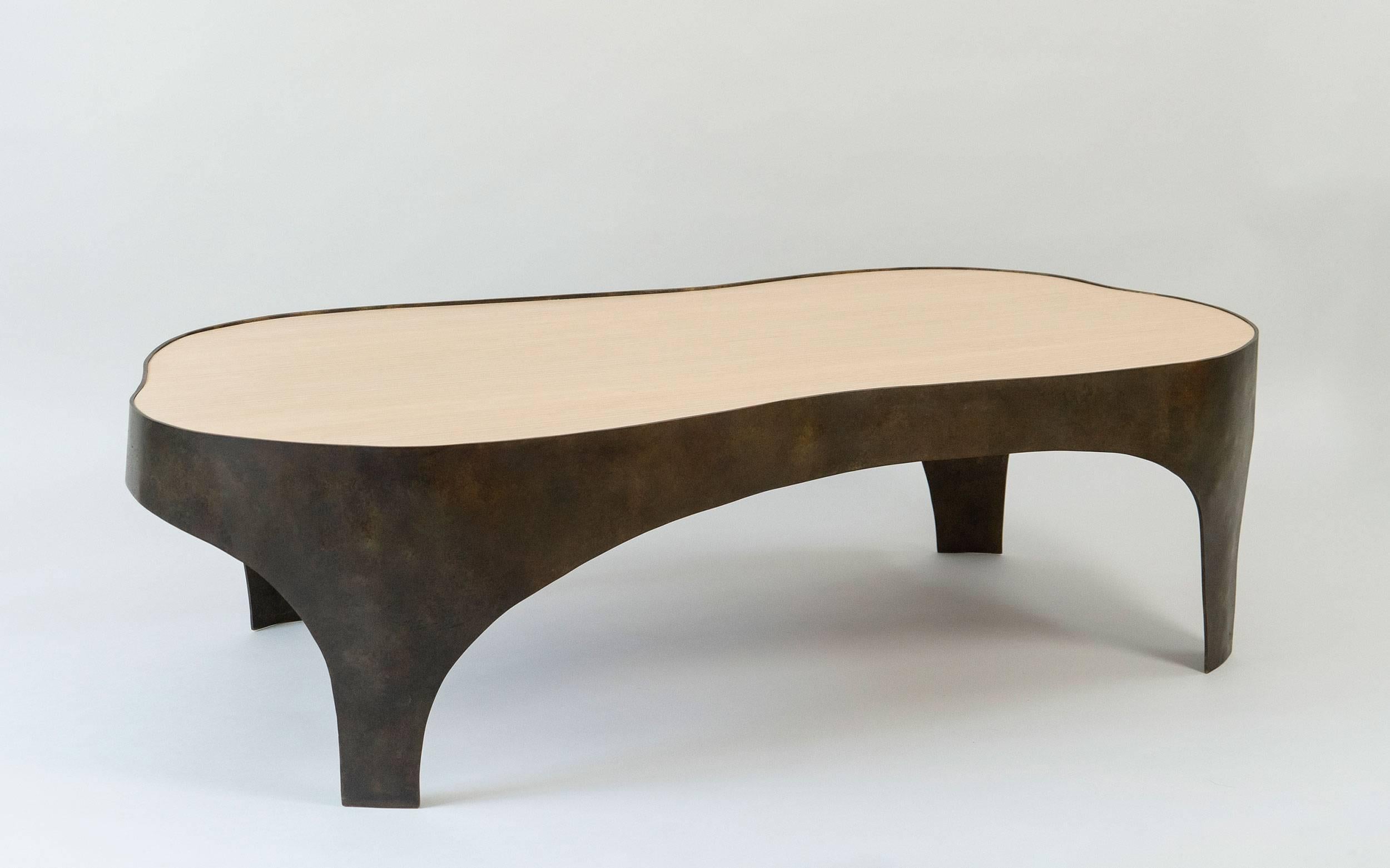 Bronze coffee table with an anthropomorphic form. 
The legs and apron are drawn in bronze and support a set  top in Anigre wood.. 
The piece seem alive  as the artist has imbued it with movement.

The top can be ebonized.