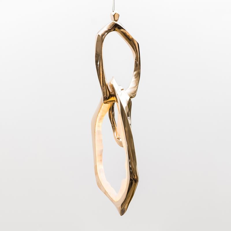 Markus Haase creates unique sculptural lighting combining hand carved wood, cast bronze, and the latest in LED technology.

The circlet pendant features organically shaped rings, cast in polished bronze, hanging delicately from a single point. One