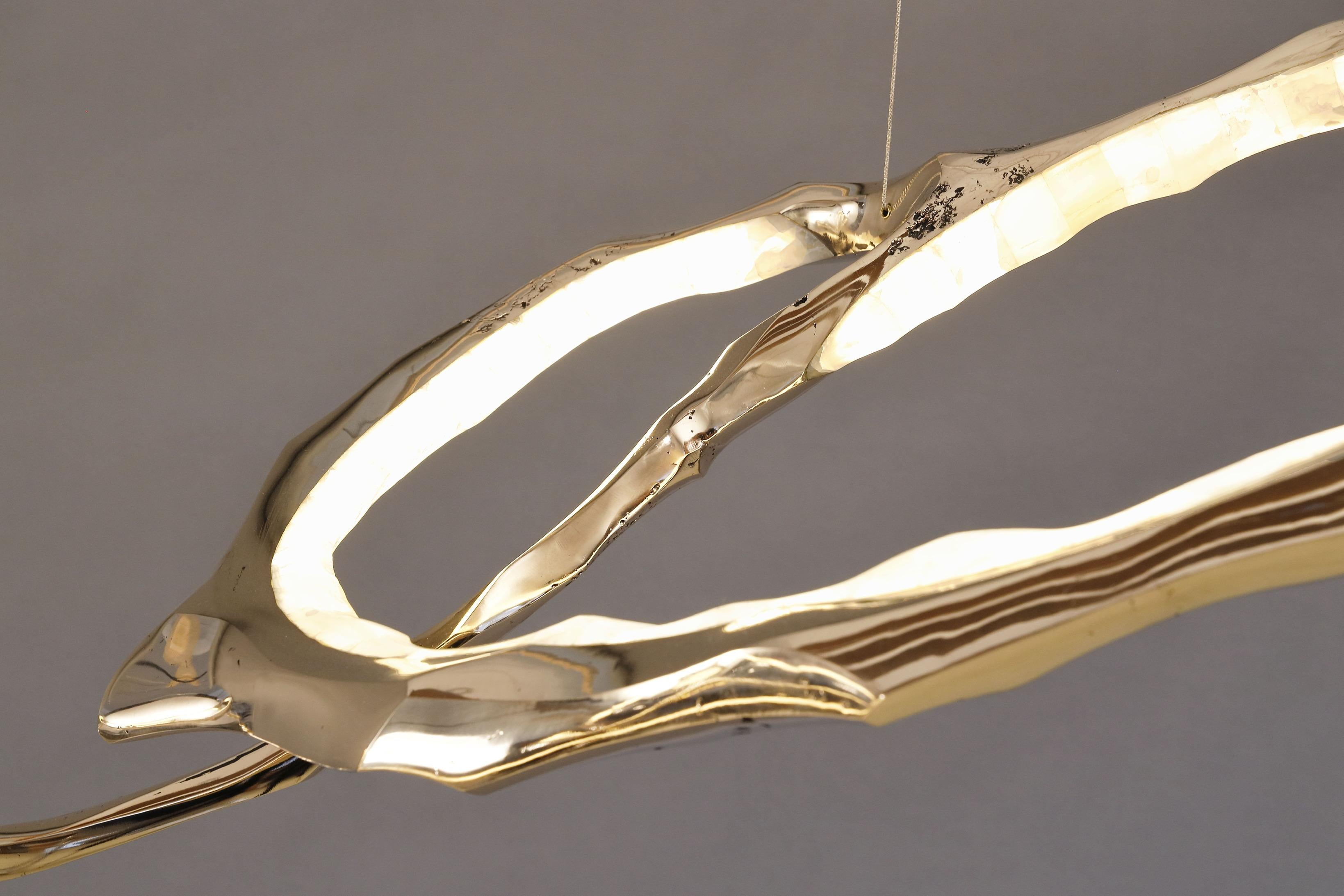Composto da una serie di anelli in bronzo e onice collegati tra loro, il lampadario Cloud Series di Markus Haase si estende per ben 3 metri, creando un ampio paesaggio di luce radiosa e scolpita. Combinando la padronanza delle tecniche di scultura