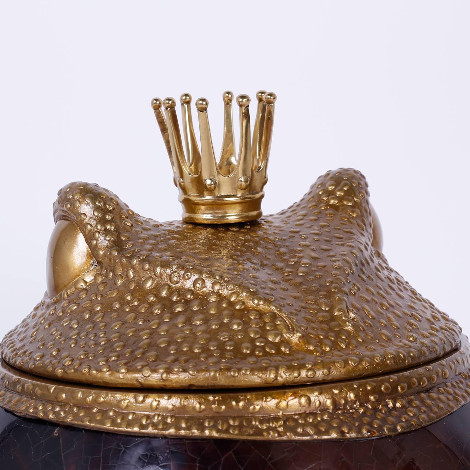 Here is an amusing royal frog box with a brass crown on a cast bronze head that operates as the lid. The body is covered in penshell and sits on cast bronze feet. Signed on the bottom Maitland-Smith.