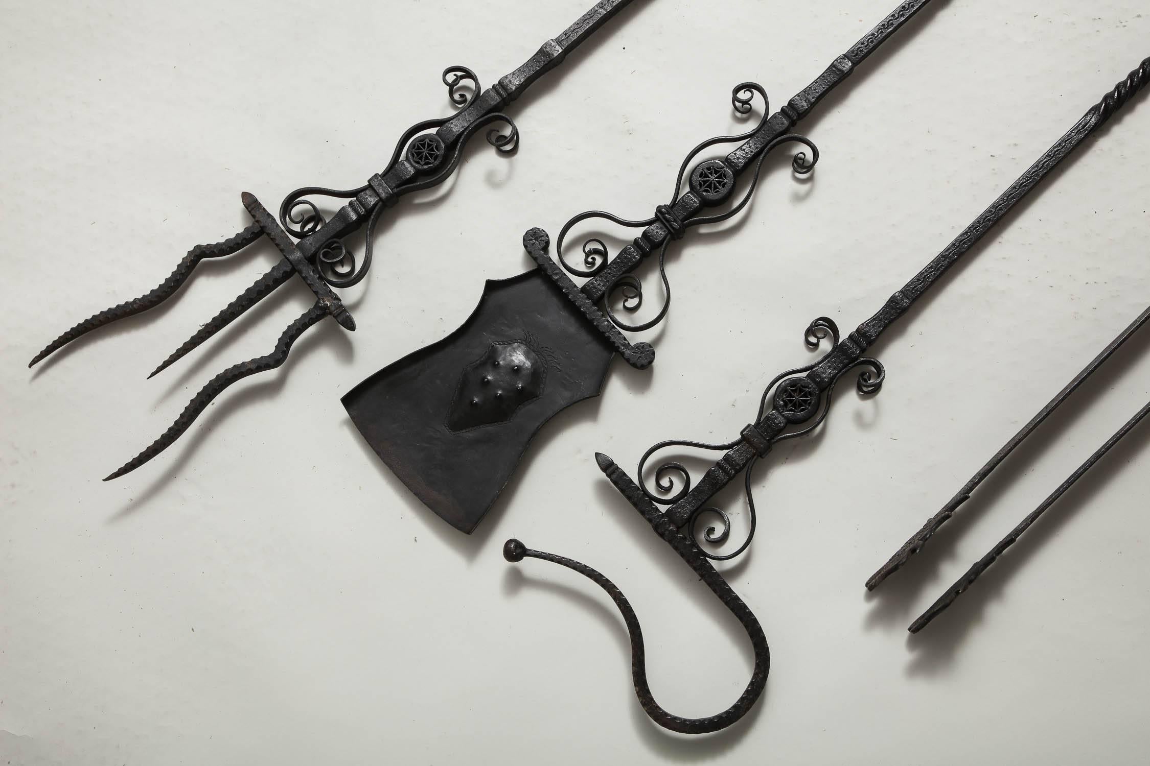 A very fine and important set of Renaissance style fire tools in the manner of Samuel Yellin, comprising shovel, tongs, hook and fork, with twist shafts in highly figured scrolled and notched wrought iron, surmounted by bronze satyr finials.
  