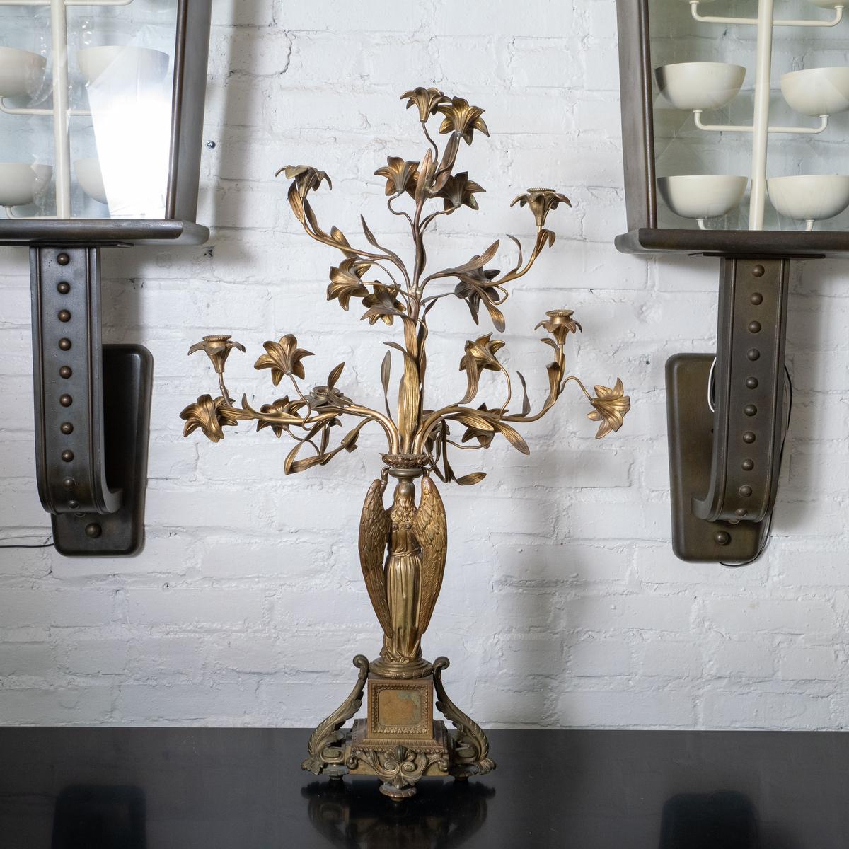 Candelabro da altare in bronzo con angelo e motivo floreale.