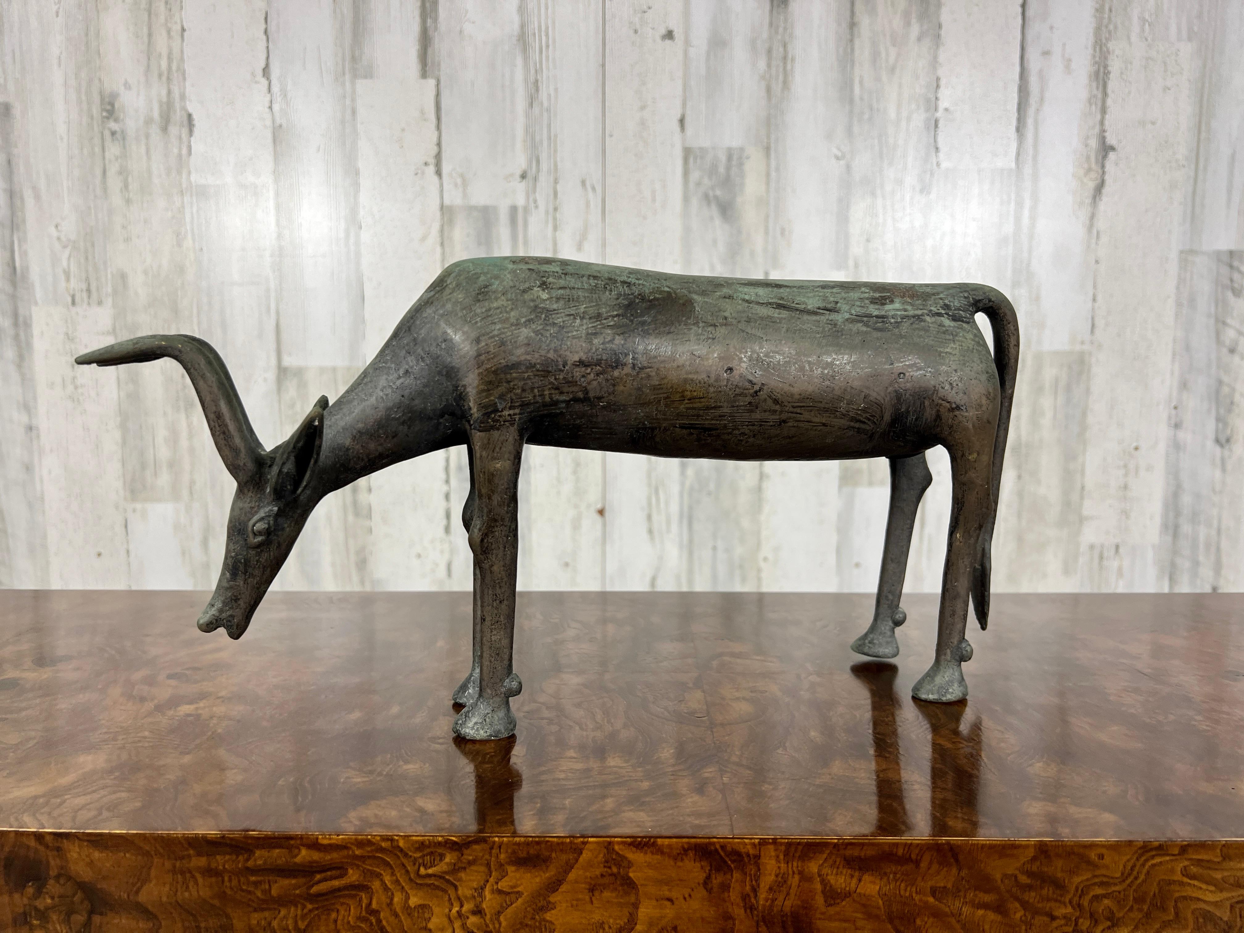 Beautiful African bronze Antelope bending its neck down to drink, in the style of the Ashanti. Great texture and detail!
