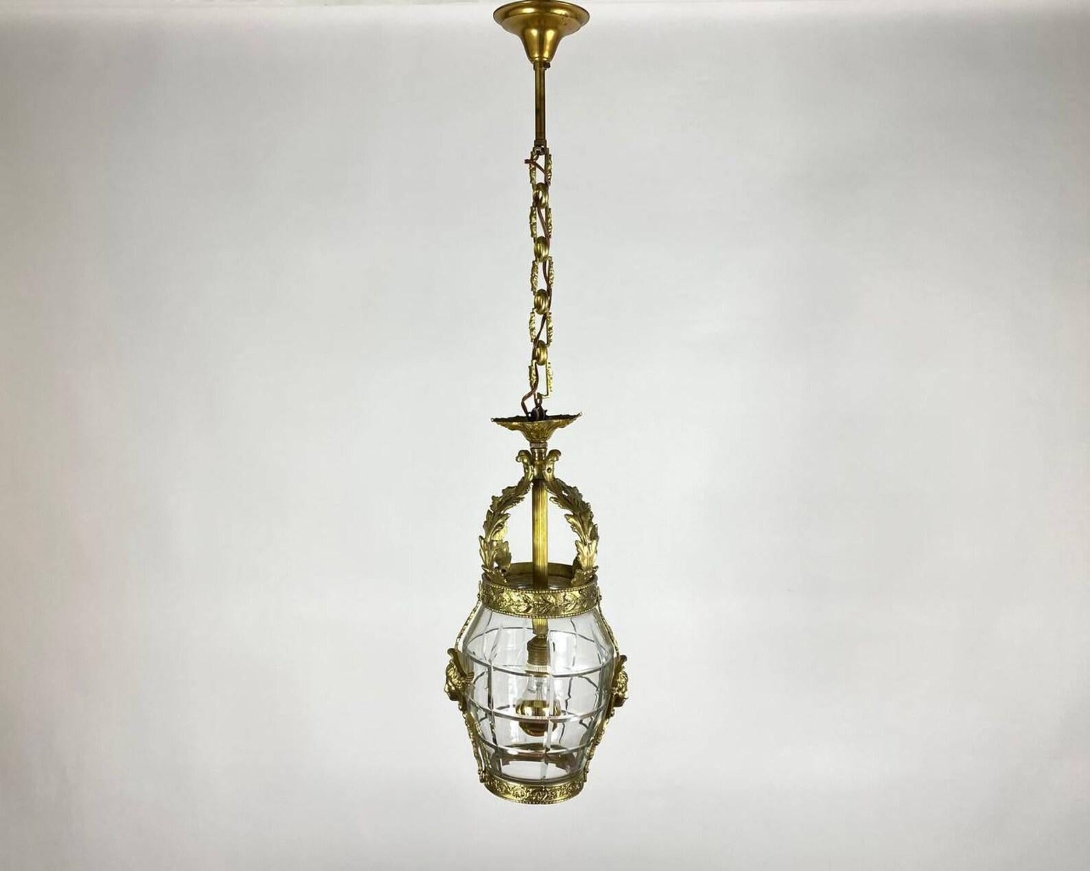 Single-light Pendant Lantern is made of bronze, polished to a mirror shine, covered with gilding. France, 1920's. 

  An ornate French 19th-20th molded glass hanging lantern has elongated molded and cut-glass body surmounted with floral wreaths and