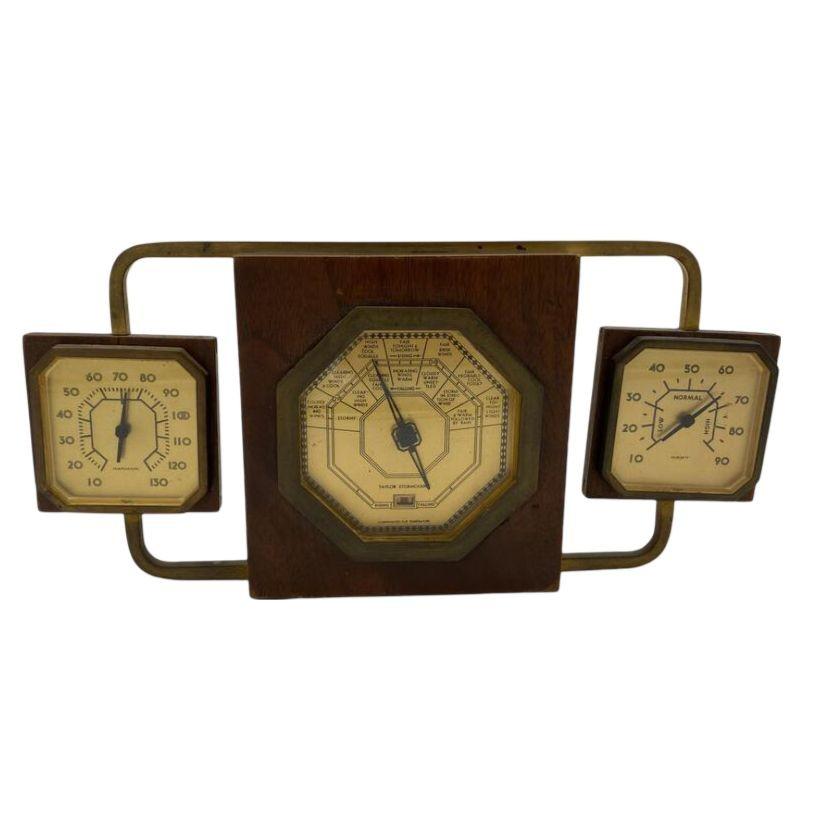 Here is a 1933 Taylor Art Deco Stormoguide Weather Station with Stormguide, thermometer and humidity gauges. The cluster features a center gauge with two gauges suspending by a bronze loop.

Dimensions: 6.75