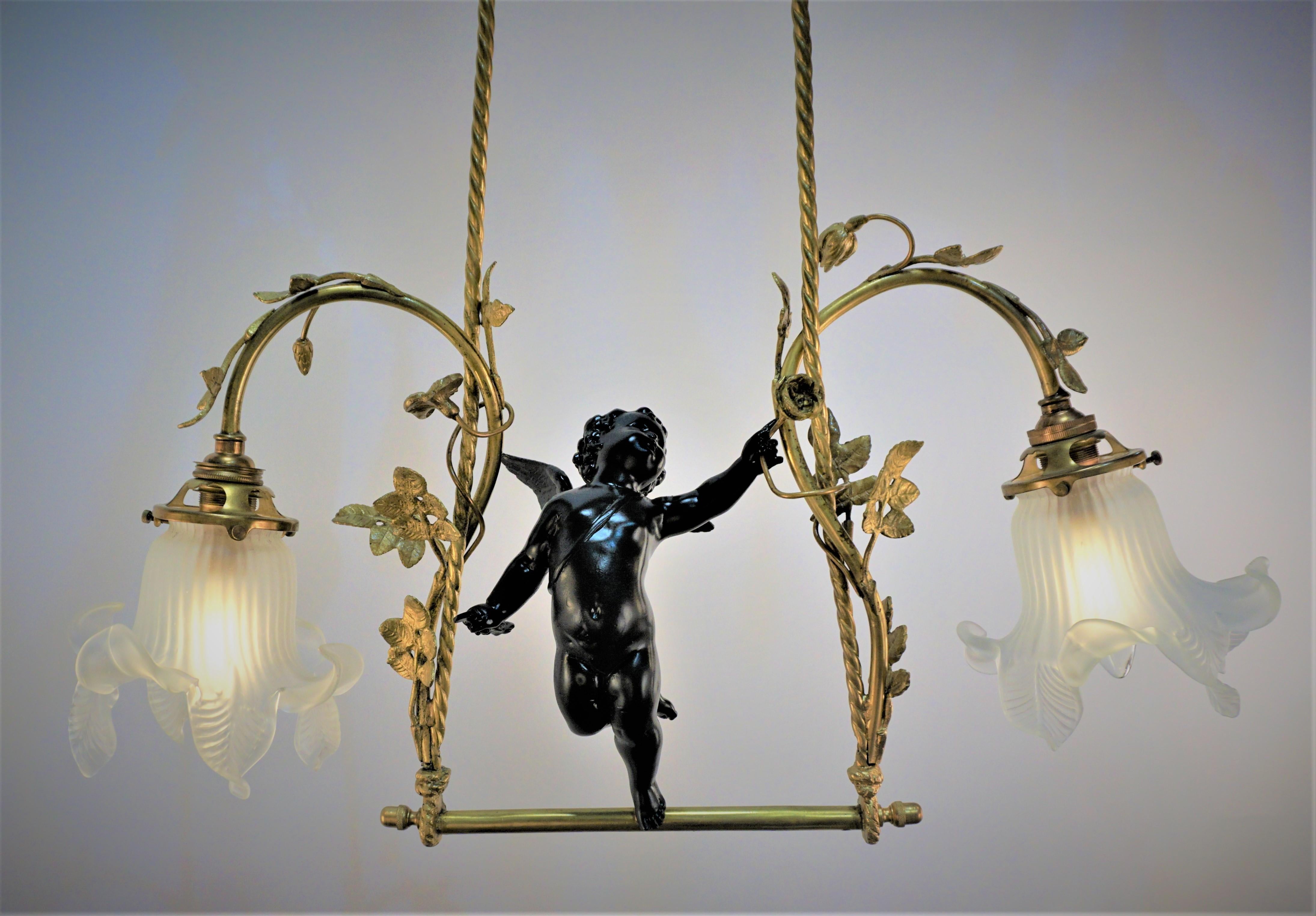 Handcrafted in France during 1910's. This gorgeous chandelier features hand blown glass tulip shades and black lacquer cherub center piece with bronze flowers. 