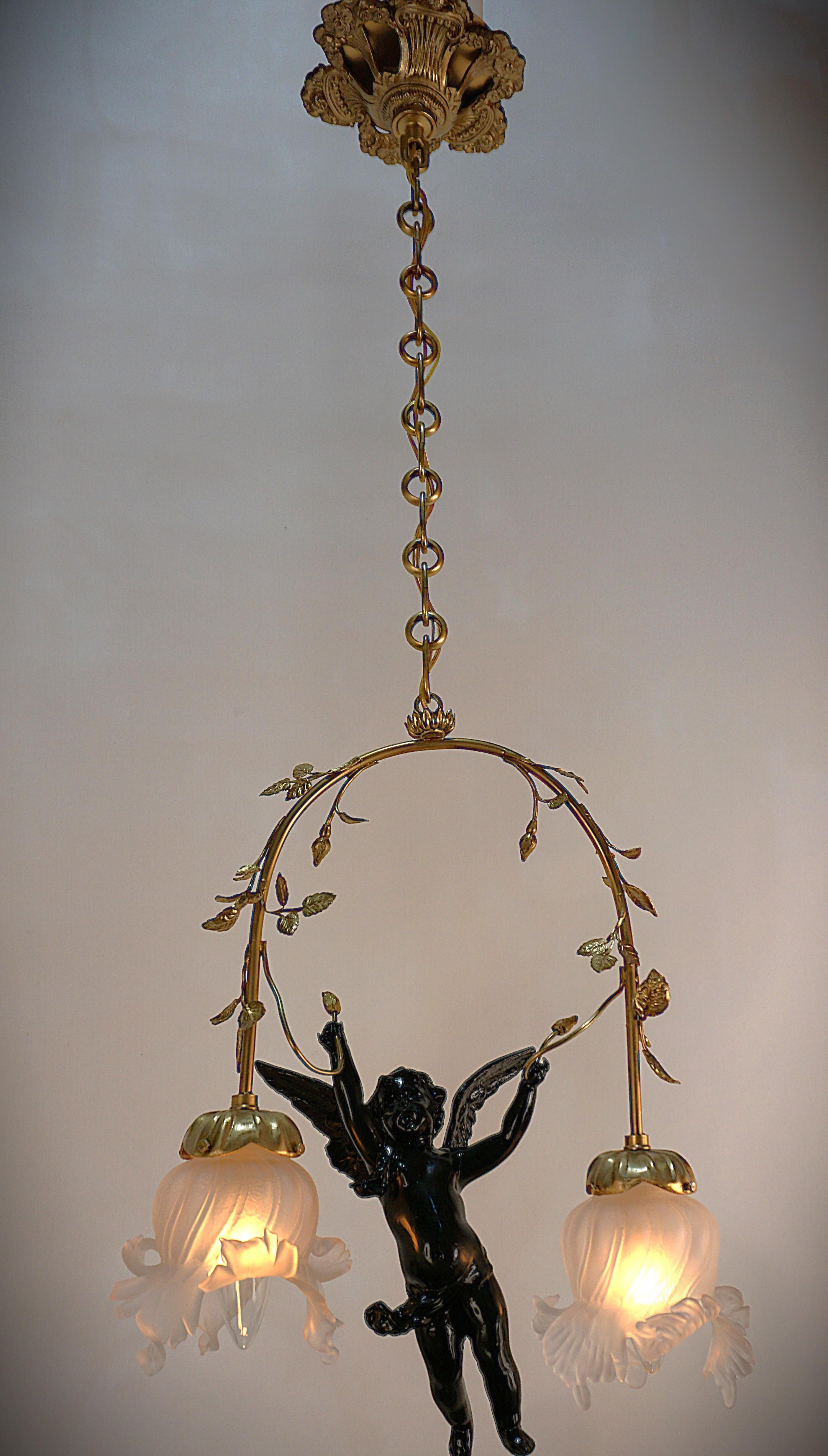 Handcrafted in France during 1910's. This gorgeous chandelier features hand blown glass tulip shades and black lacquer cherub center piece with bronze flowers Frame.
Professionally rewired and ready for installation.
Measurements: 8