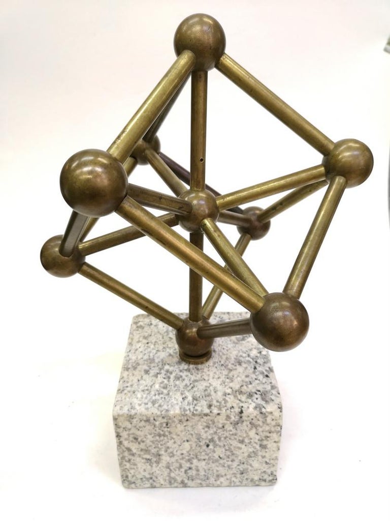 This sculpture depicts the Atomium sculpture, originally in Brussels. It's shaped as a cell of an iron crystal magnified. It's nicely done out of bronze and brass and sits on a marble base.