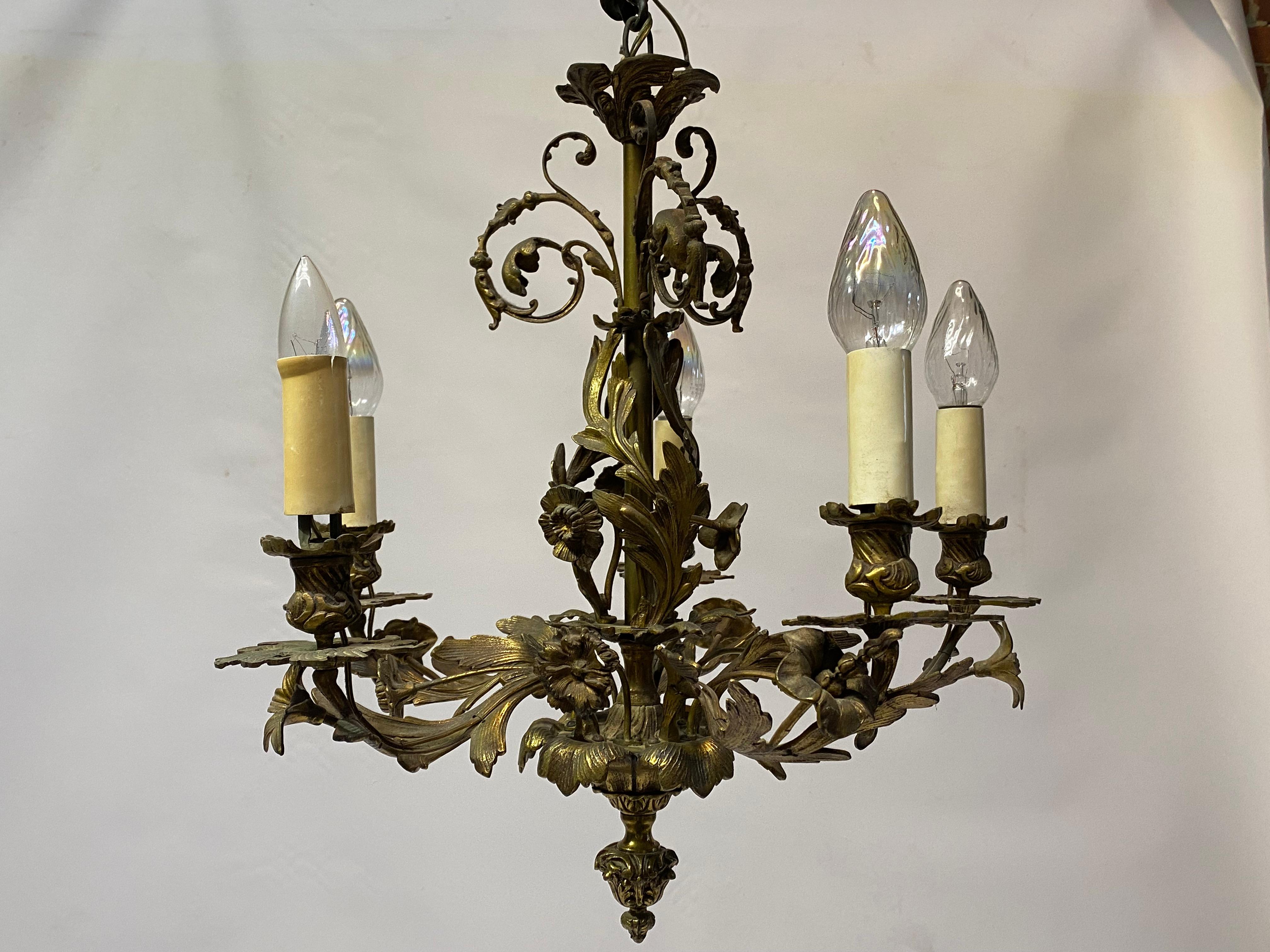 Beautiful and finely cast bronze floral and scroll chandelier. circa 1950-60. An elegant statement and great period lighting fixture that features five single row of 