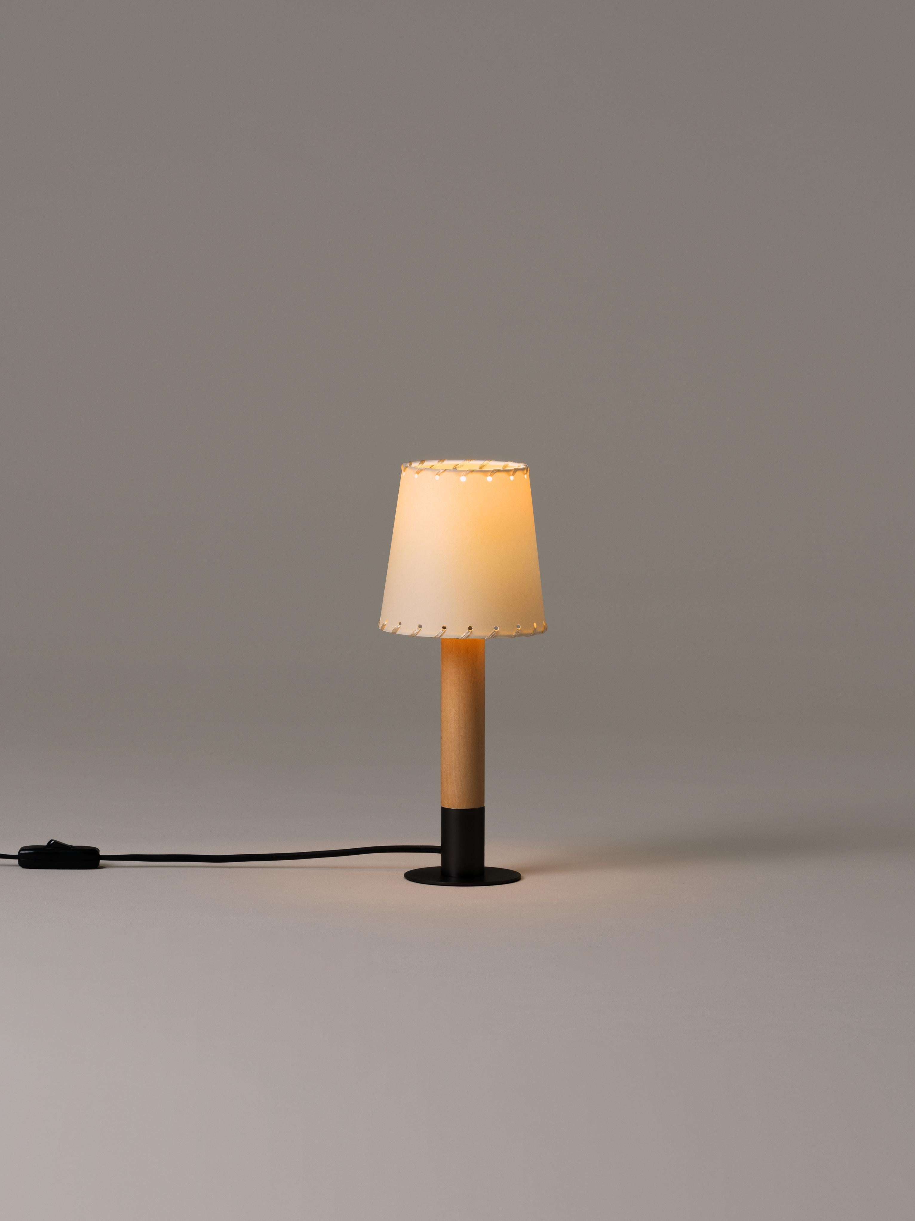 Bronze Básica Mínima table lamp by Santiago Roqueta, Santa & Cole
Dimensions: D 12 x H 30 cm
Materials: Bronze, birch wood, stitched parchment.

Básica Mínima is the pocket edition of the Básica lamp. On its own or with others, it combines