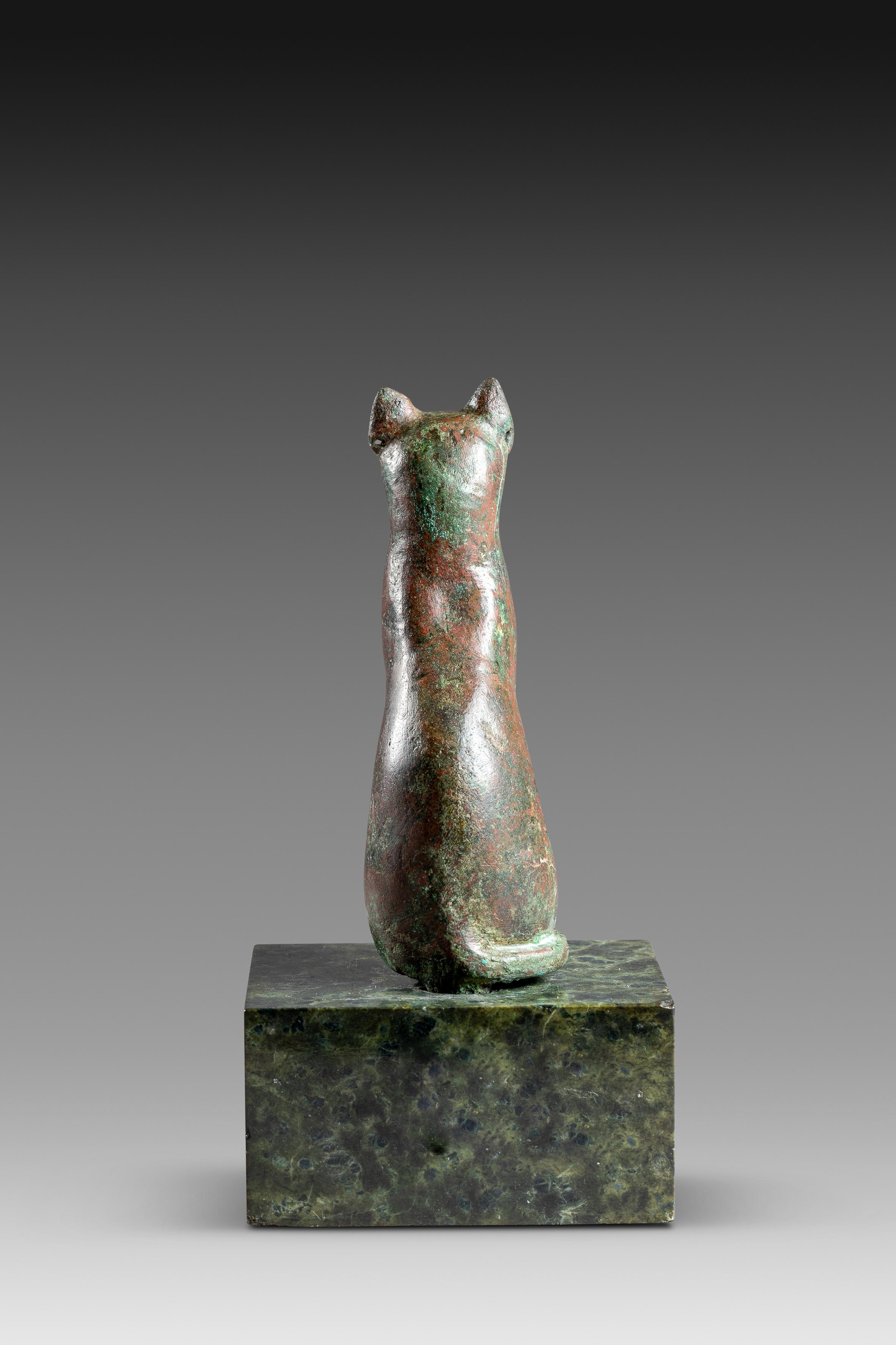 Bronze Bastet figurine, Egypt, late period '664–332 BCE' this small green and red covered bronze figurine dating from the Late Period (664–332 BCE) represents the Egyptian goddess Bast or Bastet as a sitting cat. On the left ear one can notice a